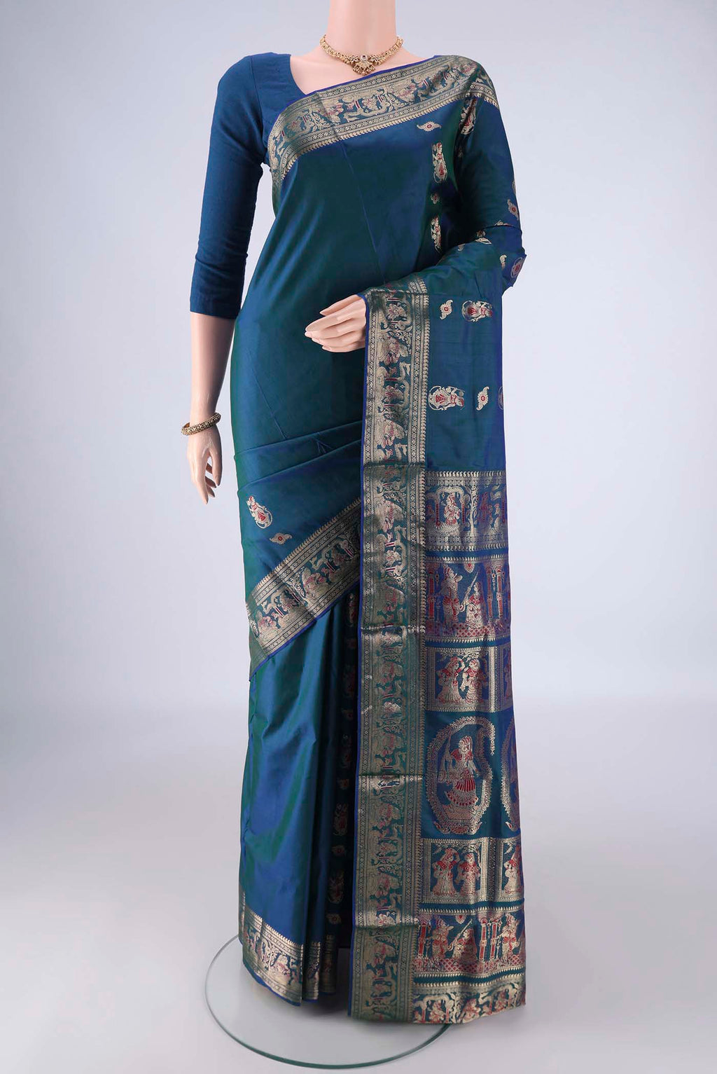 Peacock Blue Baluchari Silk Saree with Zari And Thread Butta on the body and Zari Border.  displayed on a mannequin