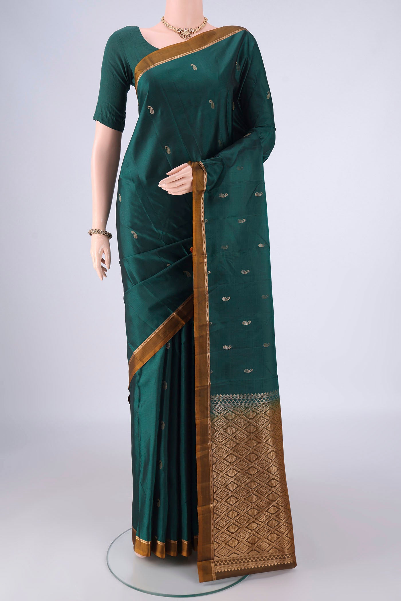 Bottle Green Kanjivaram Silk Saree with Zari Butta on the body and Plain Border.  displayed on a mannequin