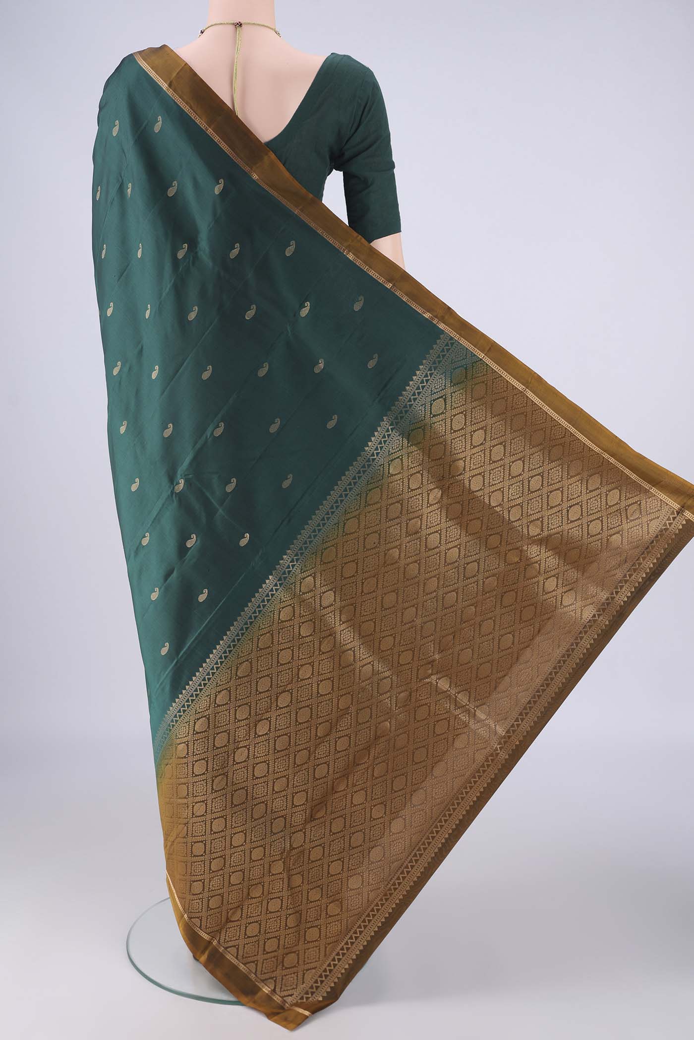 Flat view of Bottle Green Kanjivaram Silk Saree with Zari Butta on the body and Plain Border. 