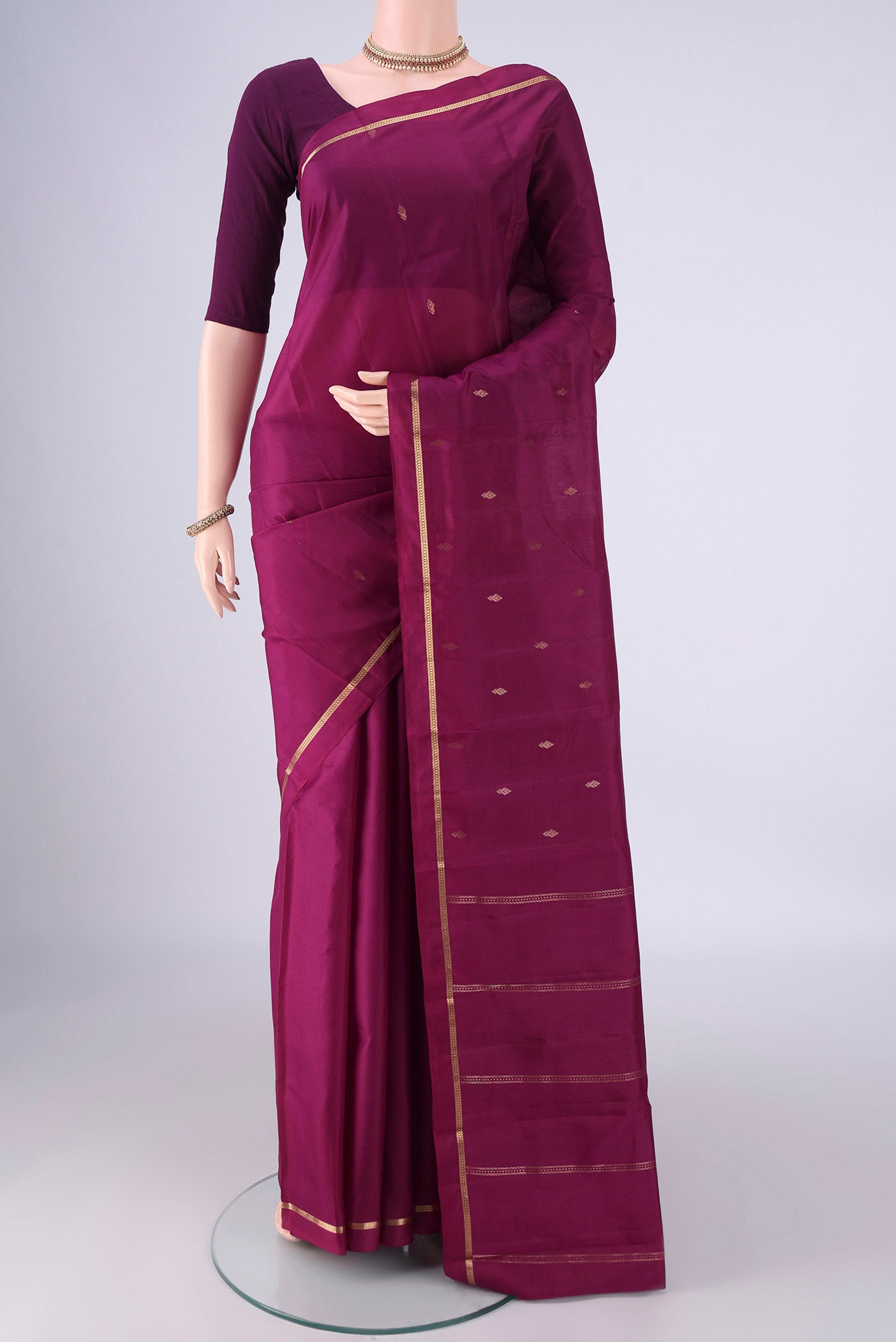 Magenta Kanjivaram Silk Saree with Zari Butta on the body and Plain Border.  displayed on a mannequin