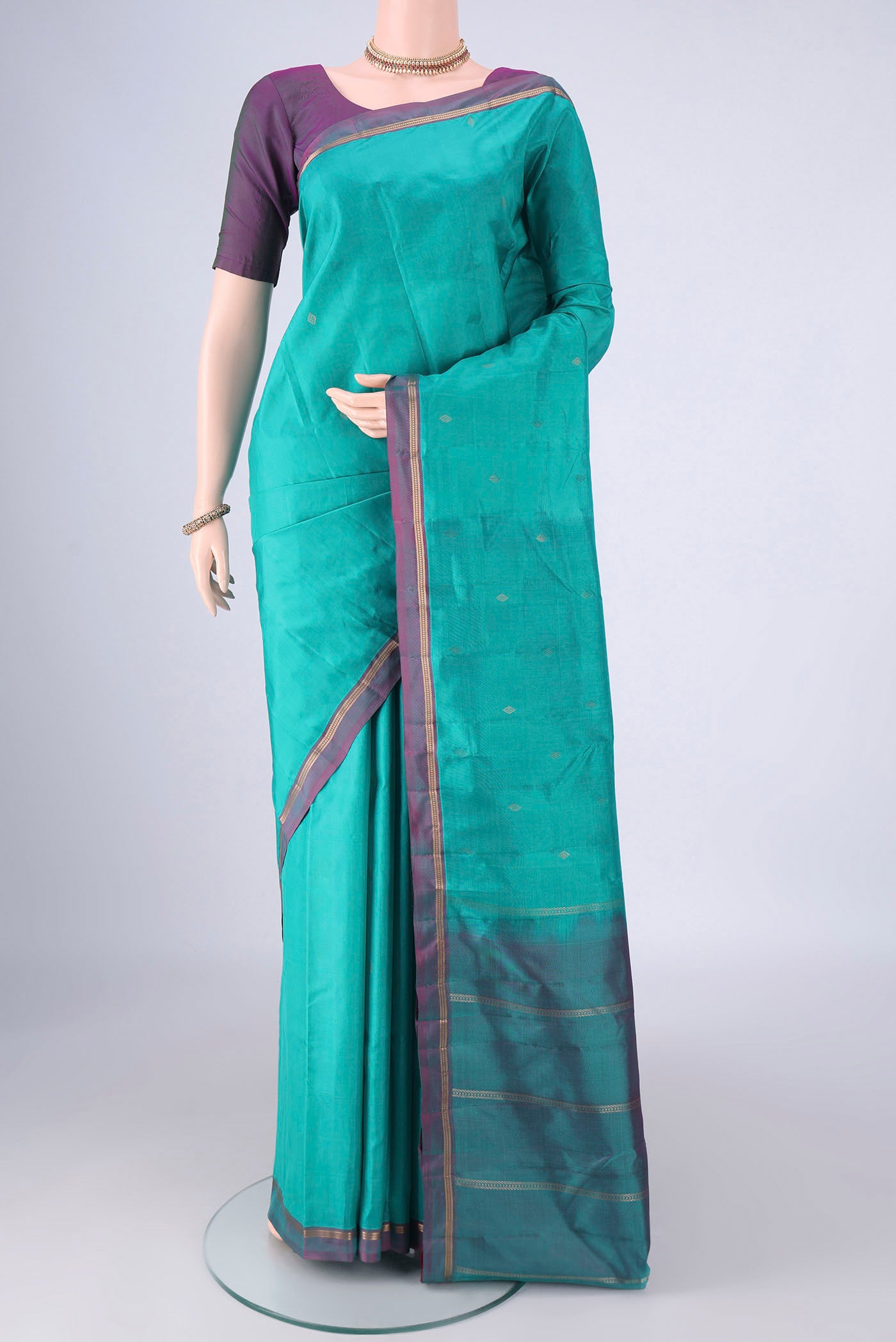 Turquoise Kanjivaram Silk Saree with Zari Butta on the body and Plain Border.  displayed on a mannequin