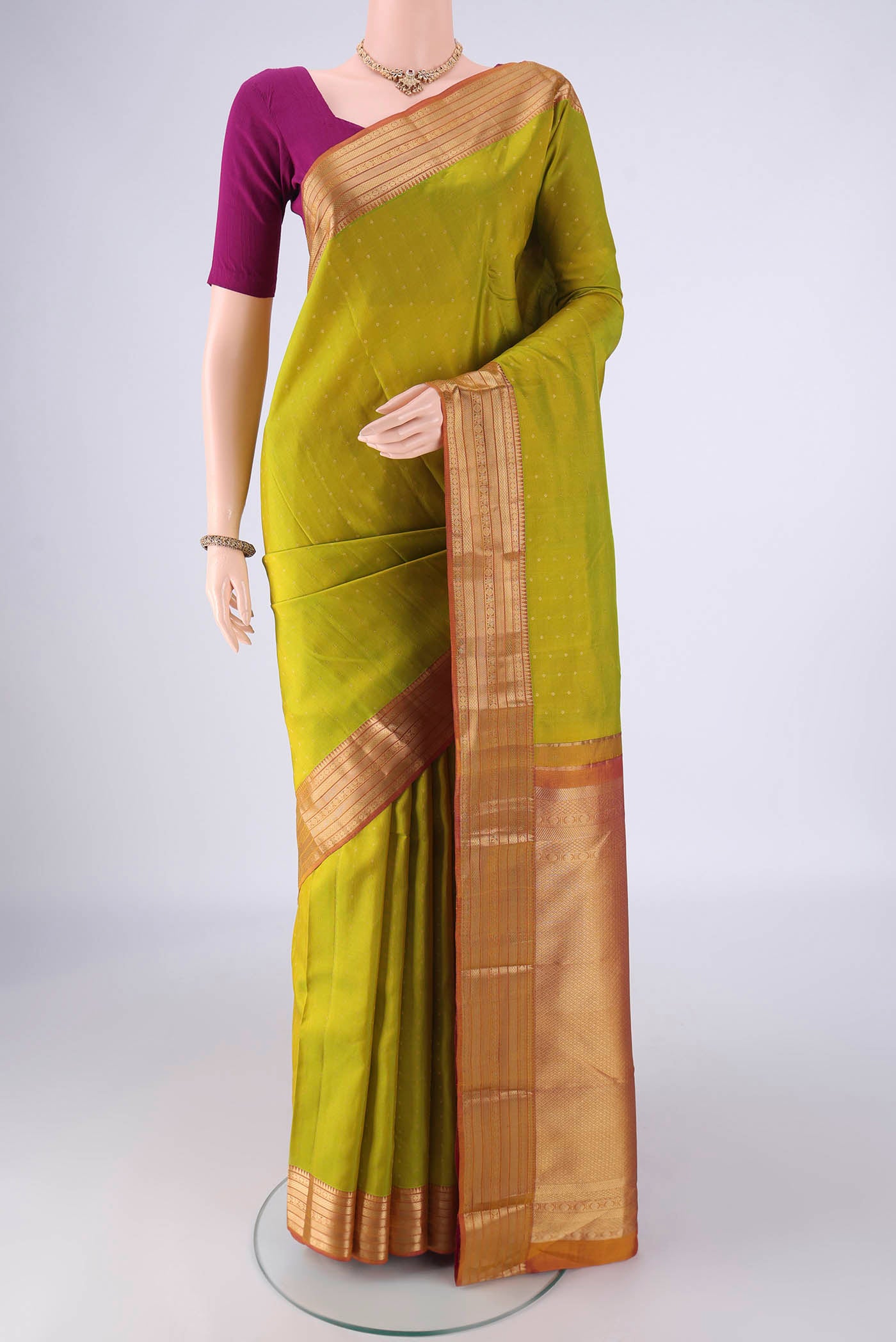 Light Green Kanchipuram Silk Saree with Zari Butta on the body and Zari Border.  displayed on a mannequin