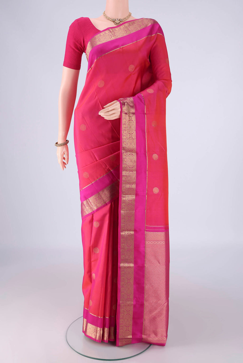 Pink Kanchipuram Silk Saree with Zari Butta on the body and Zari Border.  displayed on a mannequin
