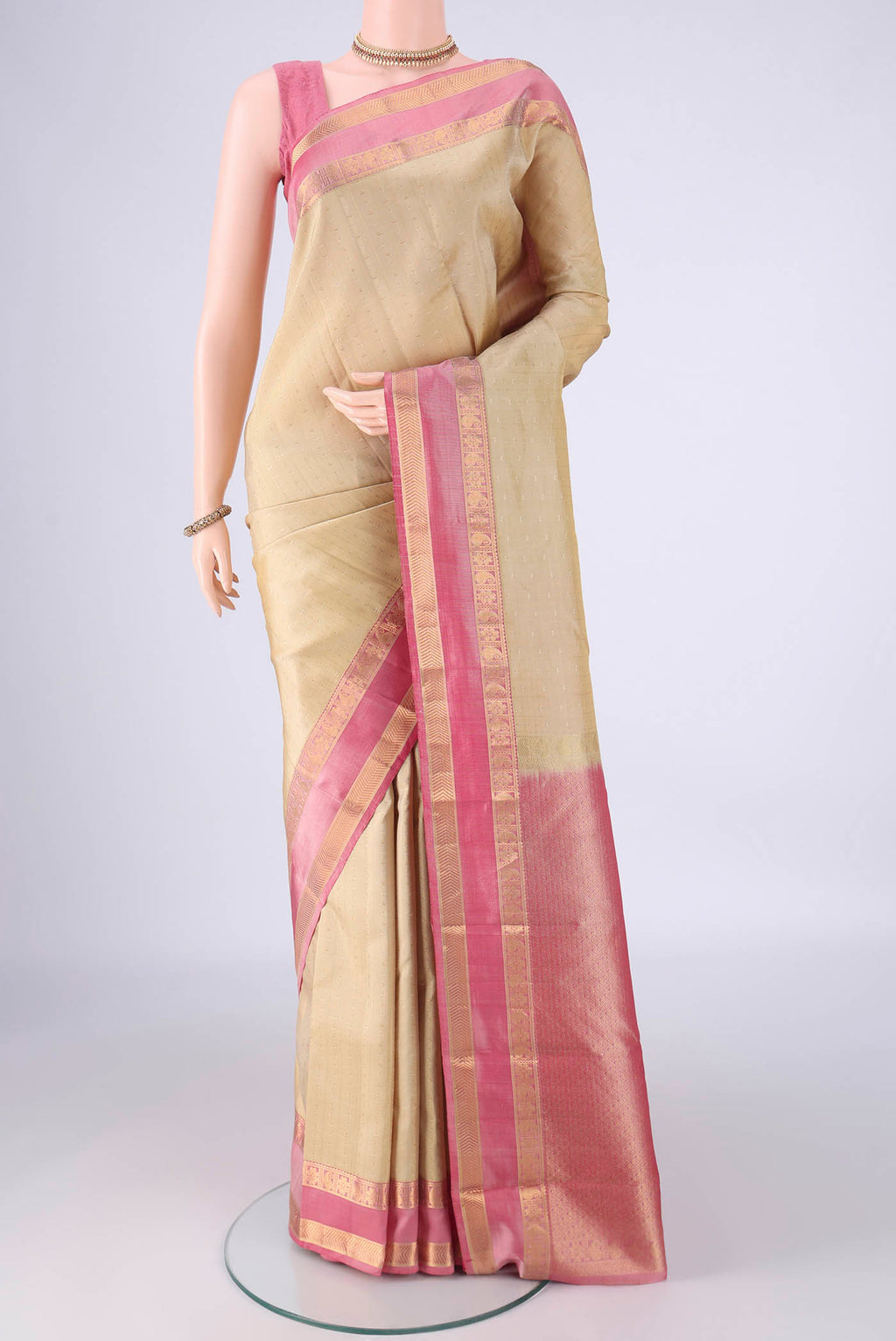Cream Kanchipuram Silk Saree with Zari Butta on the body and Zari Border.  displayed on a mannequin