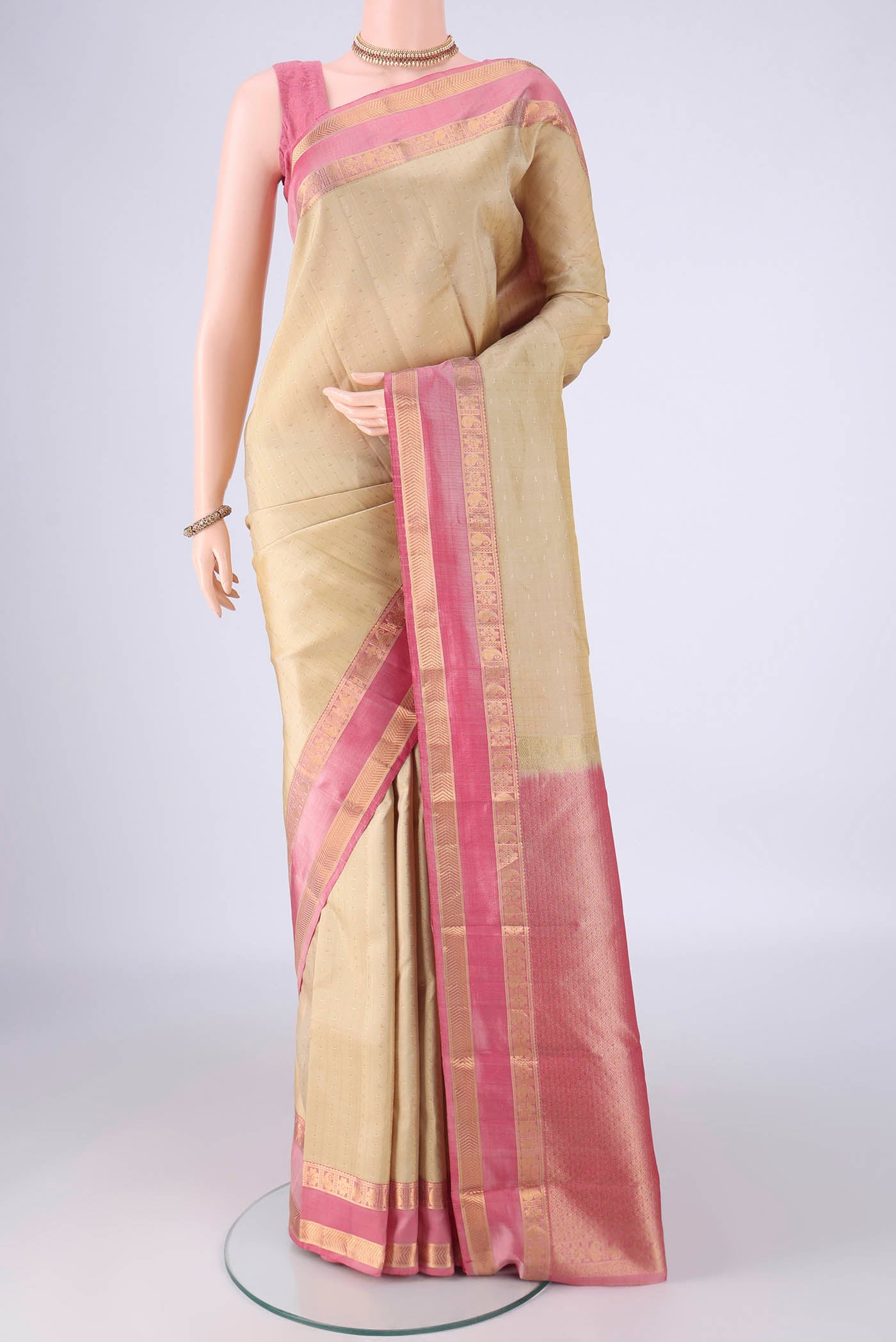 Cream Kanchipuram Silk Saree with Zari Butta on the body and Zari Border.  displayed on a mannequin