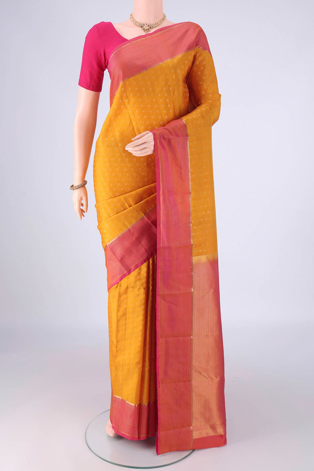 Yellow Kanchipuram Silk Saree with Zari Butta on the body and Plain Border.  displayed on a mannequin