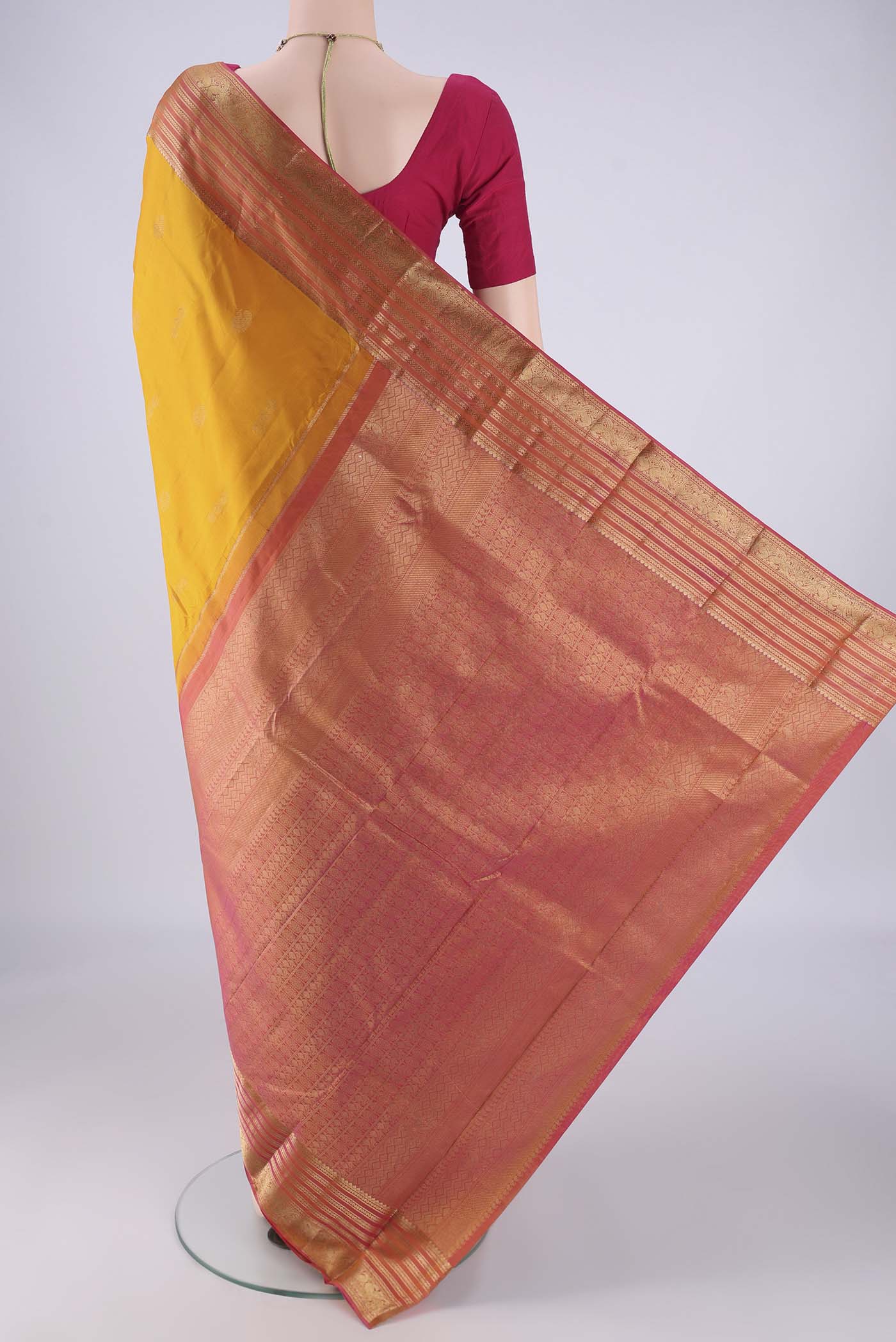 Flat view of Yellow Kanchipuram Silk Saree with Zari Butta on the body and Zari Border. 