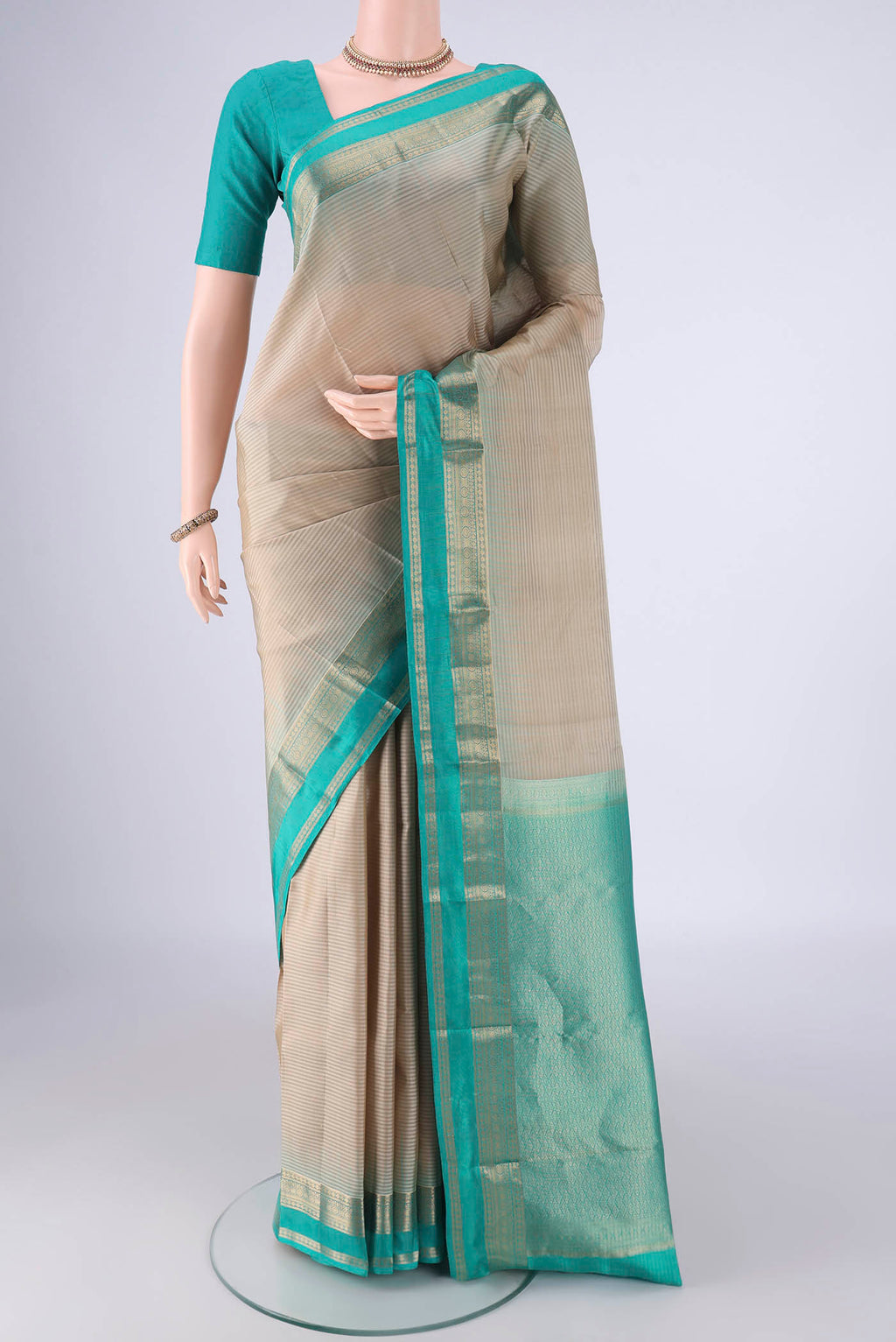Beige Kanchipuram Silk Saree with Stripes on the body and Zari Border.  displayed on a mannequin