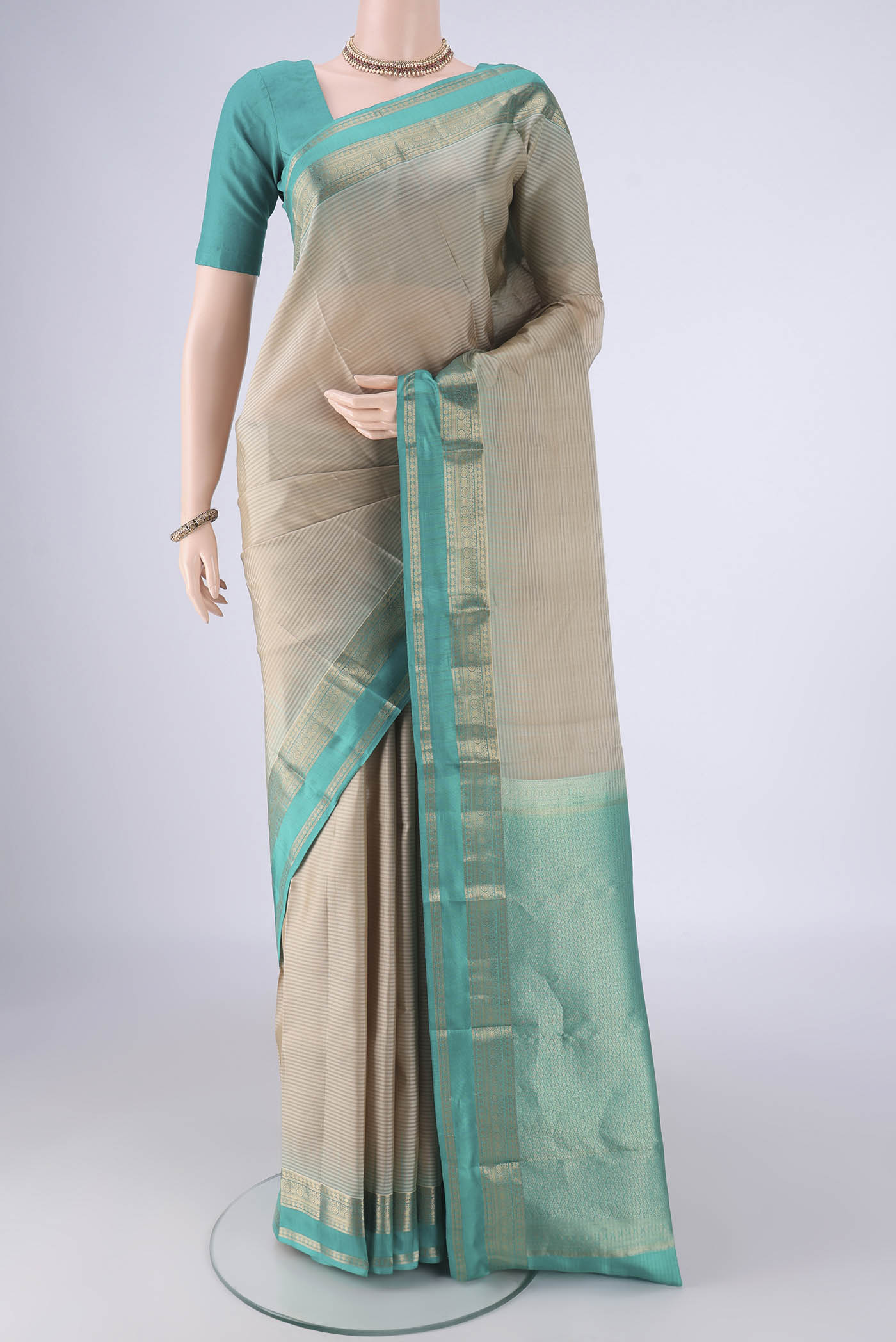 Beige Kanchipuram Silk Saree with Stripes on the body and Zari Border.  displayed on a mannequin