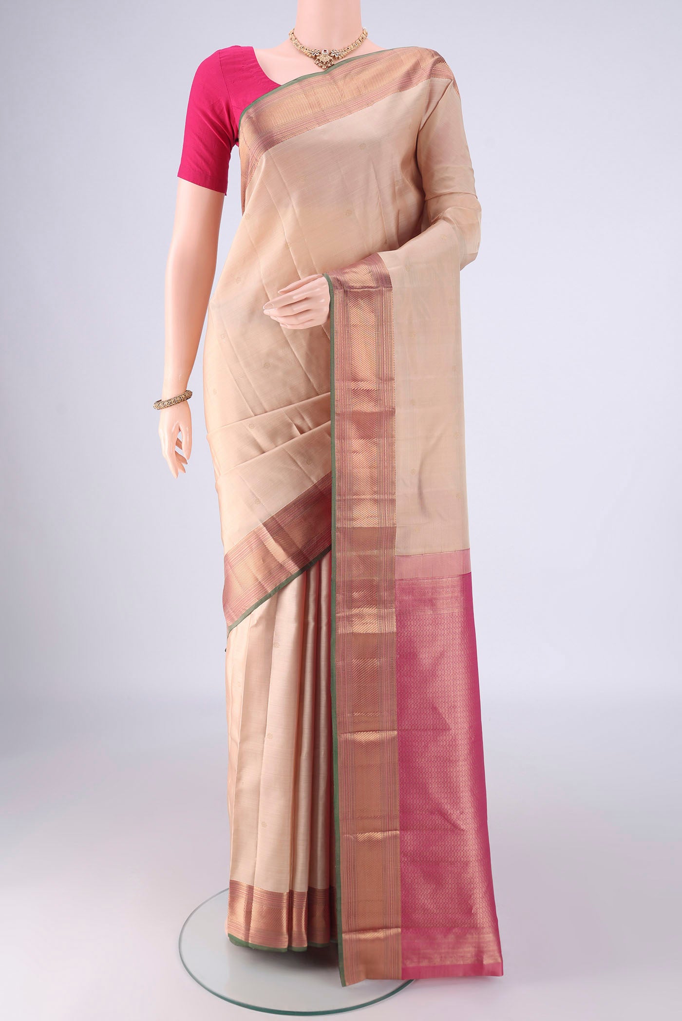 Beige Kanchipuram Silk Saree with Zari Butta on the body and Zari Border.  displayed on a mannequin