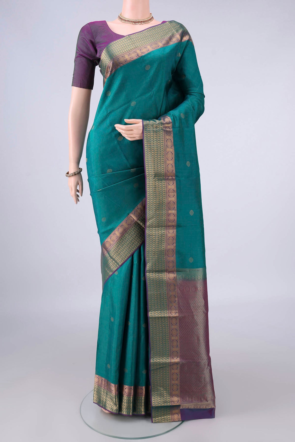 Pure Silk Sea Green Kanchipuram Saree with Zari Butta on the body and Zari Border.  displayed on a mannequin