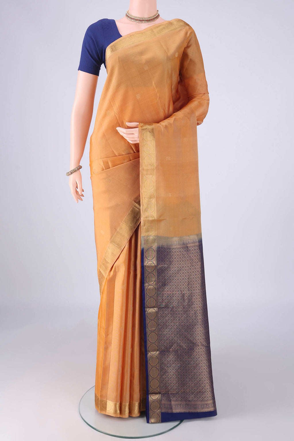 Sandal Kanchipuram Silk Saree with Zari Butta on the body and Zari Border.  displayed on a mannequin