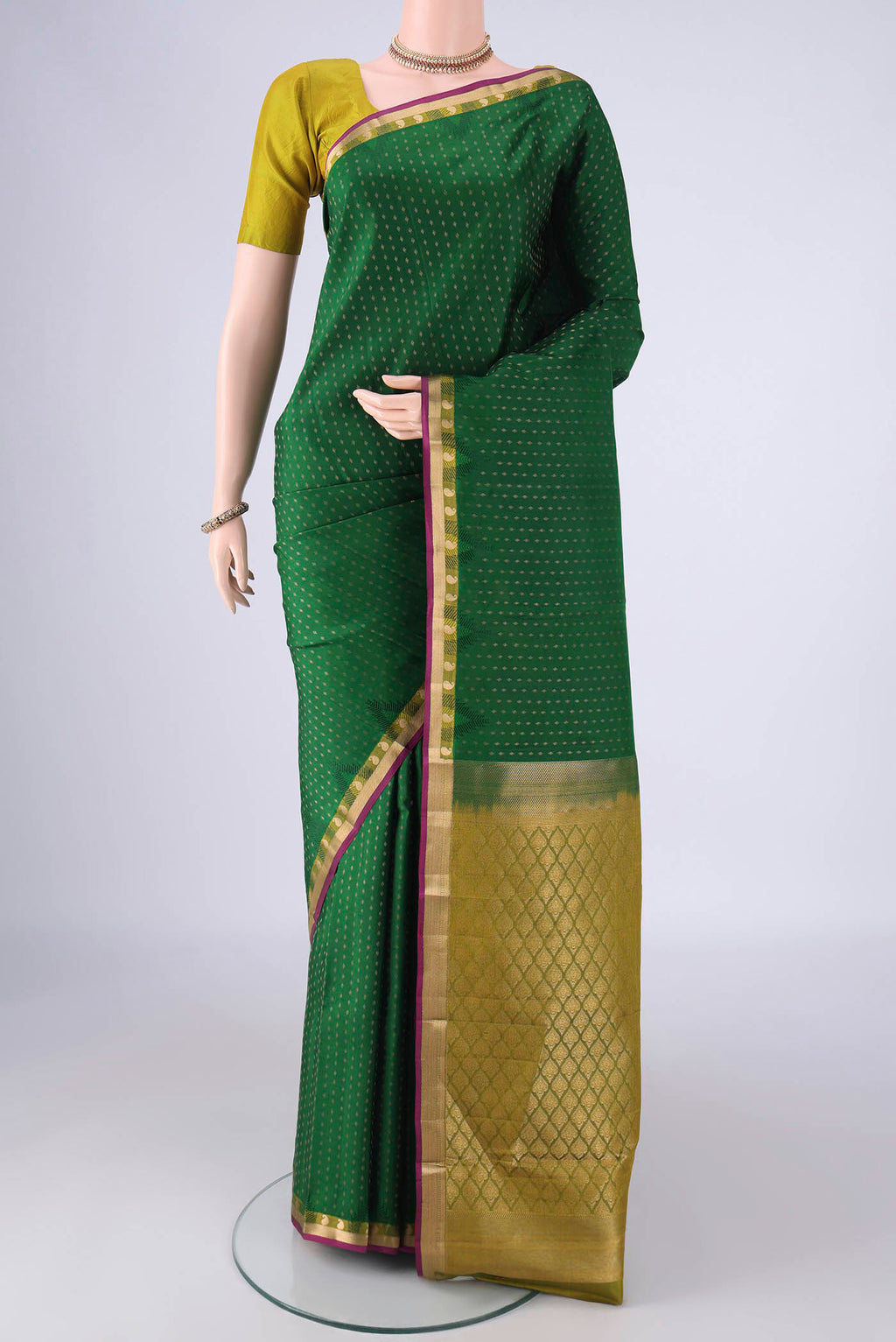 Bottle Green Kanchipuram Silk Saree with Zari Butta on the body and Zari Border.  displayed on a mannequin