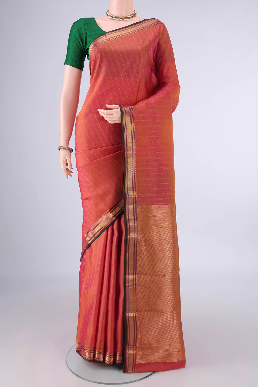 Pure Silk Brick Orange Kanchipuram Saree with Stripes on the body and Zari Border.  displayed on a mannequin
