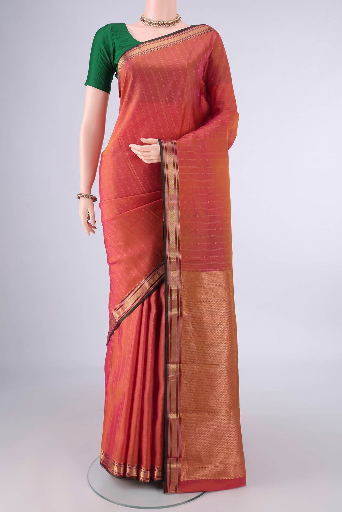 Pure Silk Brick Orange Kanchipuram Saree with Stripes on the body and Zari Border.  displayed on a mannequin