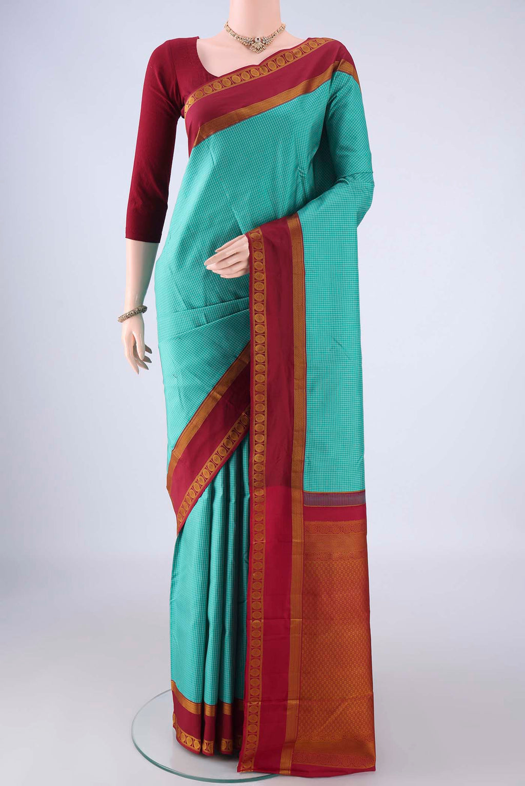 Turquoise Kanjivaram Silk Saree with Checked design on the body and Thread Border.  displayed on a mannequin