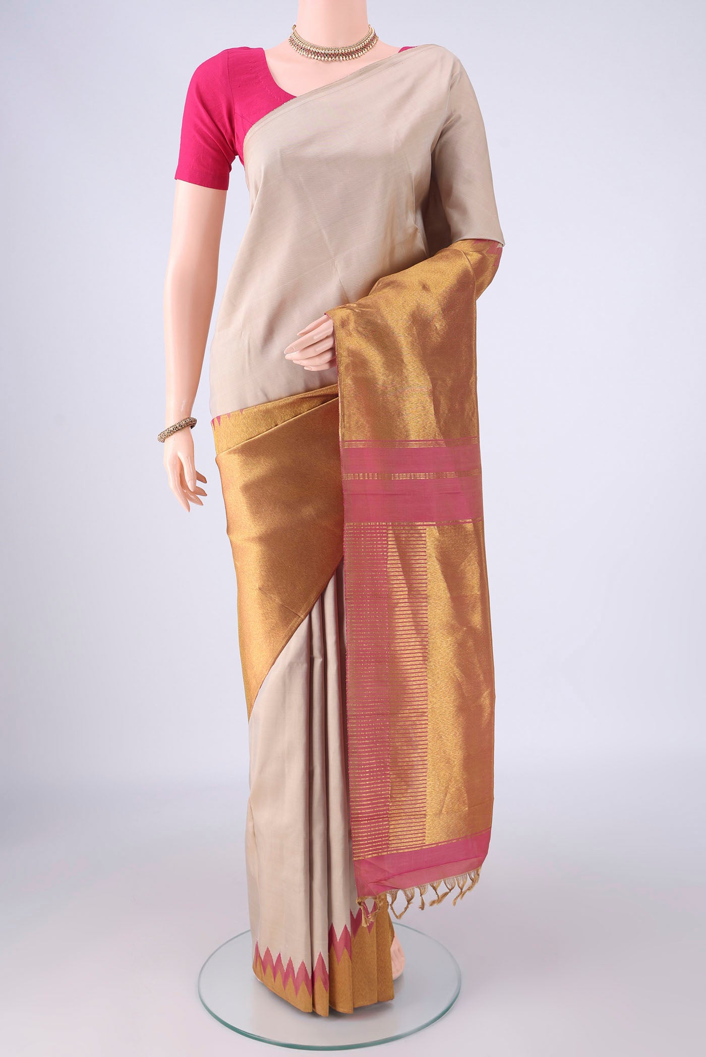 Beige Kanjivaram Silk Saree with Plain Body and Rising Temple Border.  displayed on a mannequin
