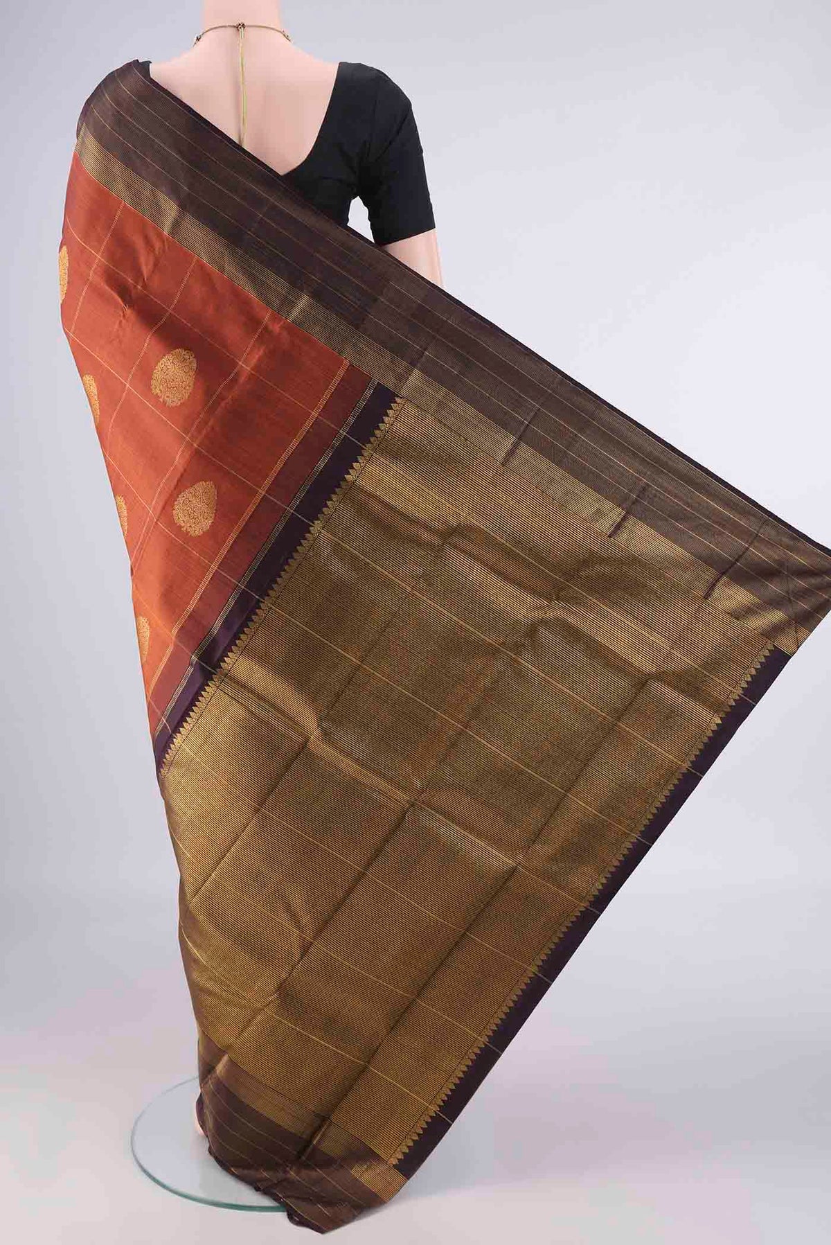 Flat view of Pure Silk Rust Kanjivaram Saree with Checked design on the body and Zari Border. 