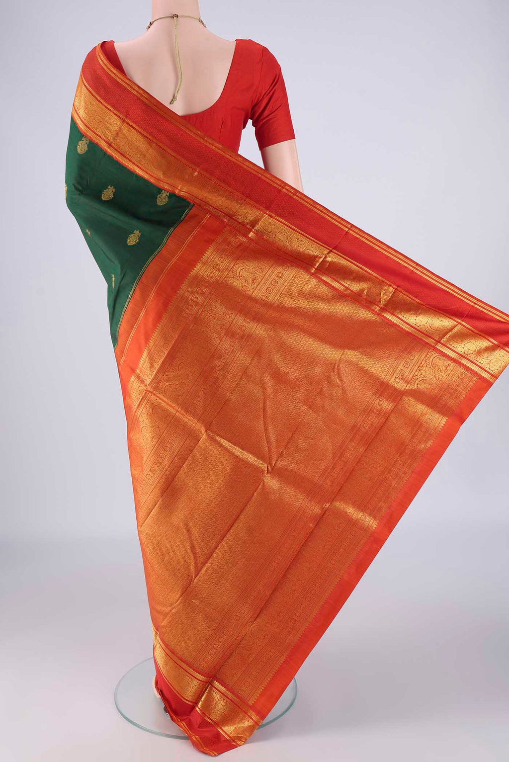 Flat view of Bottle Green Kanchipuram Silk Saree with Zari Butta on the body and Zari Border. 