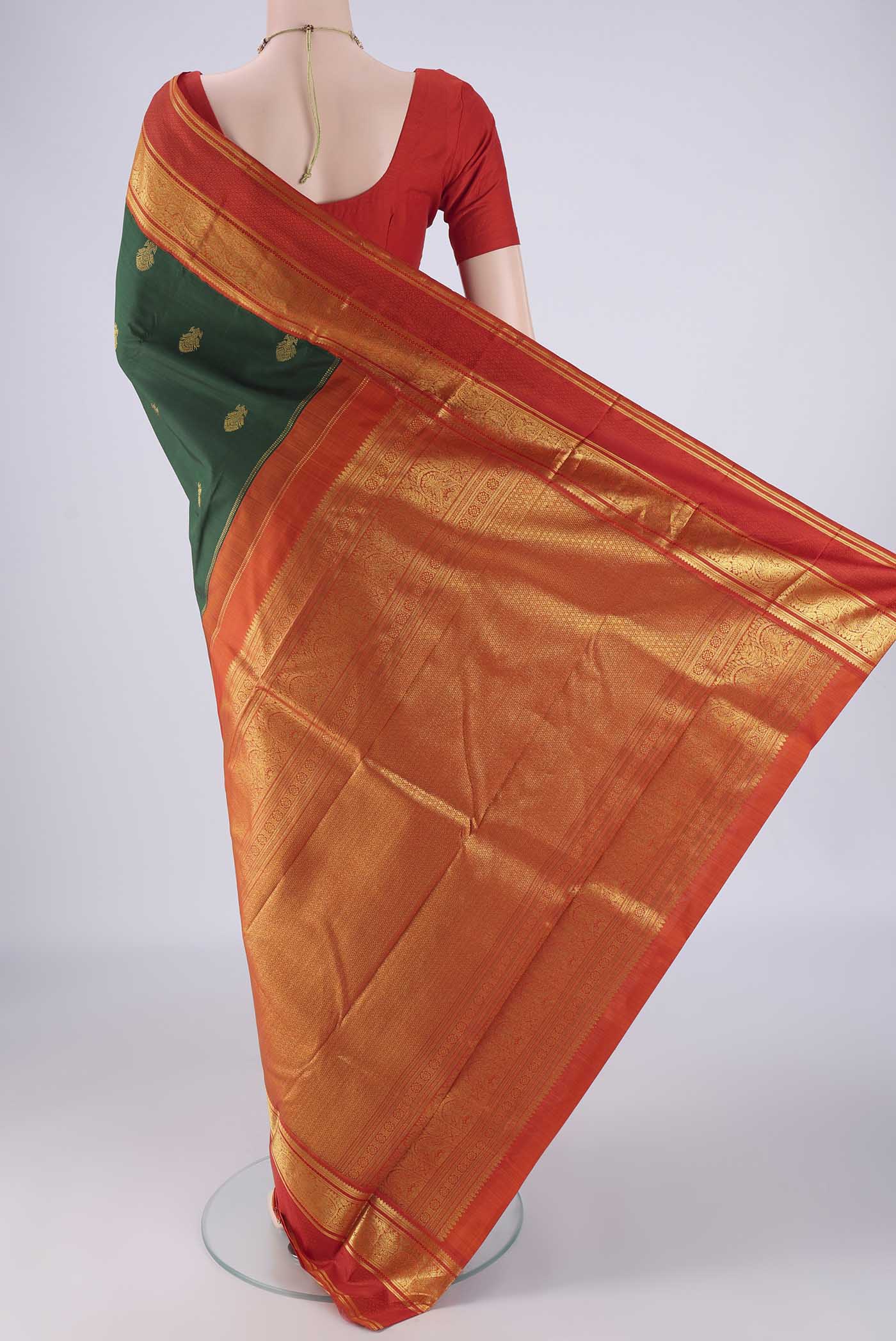 Flat view of Bottle Green Kanchipuram Silk Saree with Zari Butta on the body and Zari Border. 