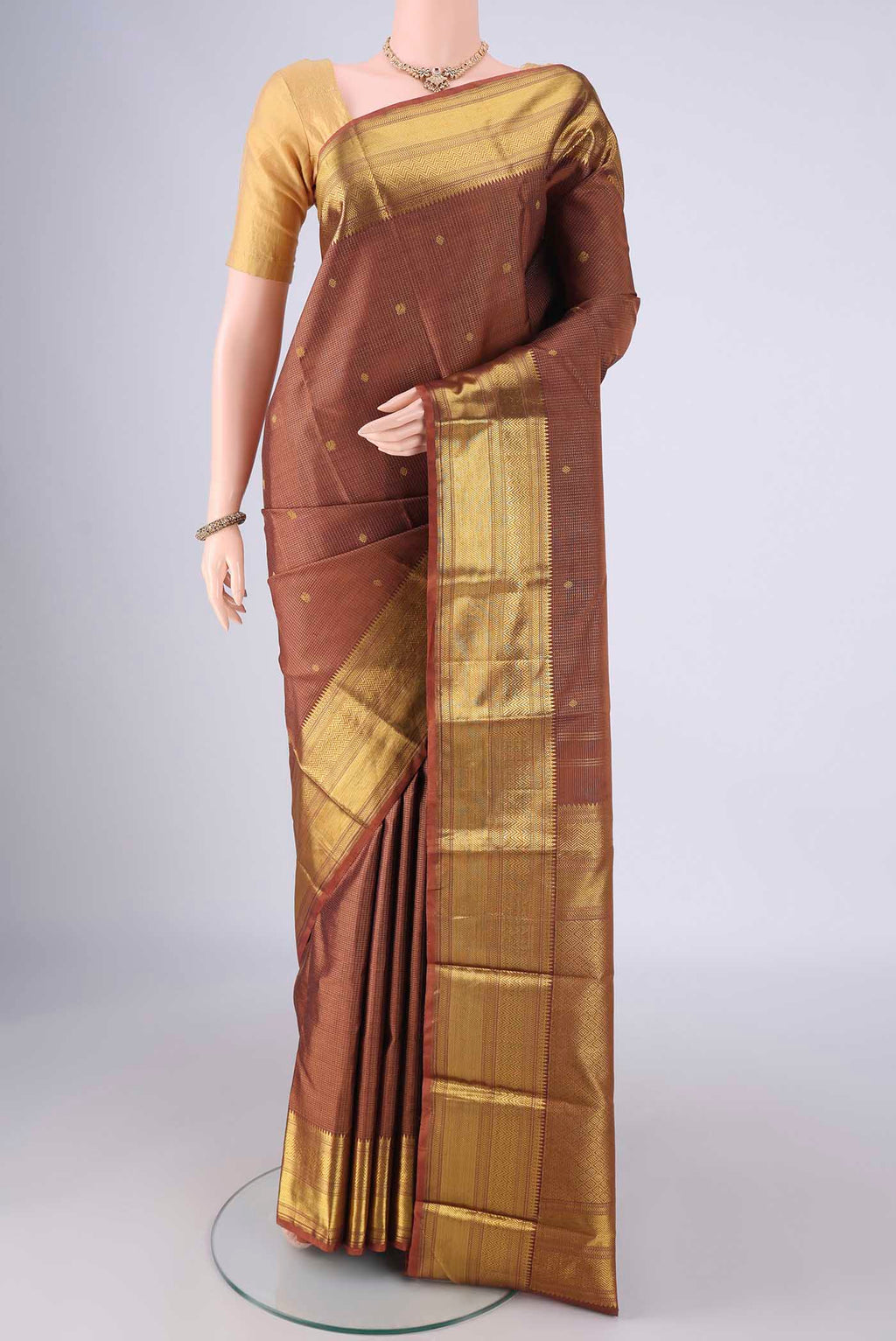 Brown Kanchipuram Silk Saree with Checked design on the body and Zari Border.  displayed on a mannequin