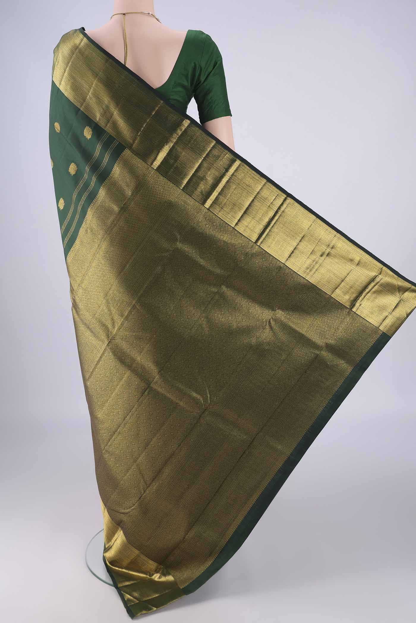 Flat view of Bottle Green Kanjivaram Silk Saree with Zari Butta on the body and Zari Border. 