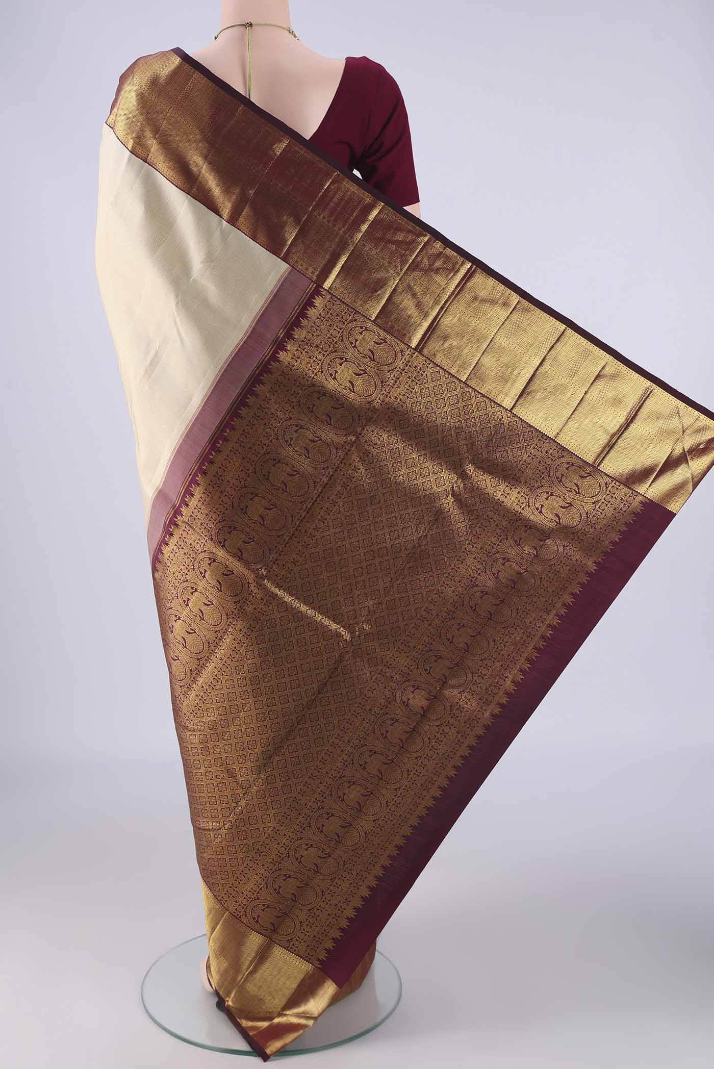 Flat view of Cream Kanchipuram Silk Saree with Stripes on the body and Temple Border. 