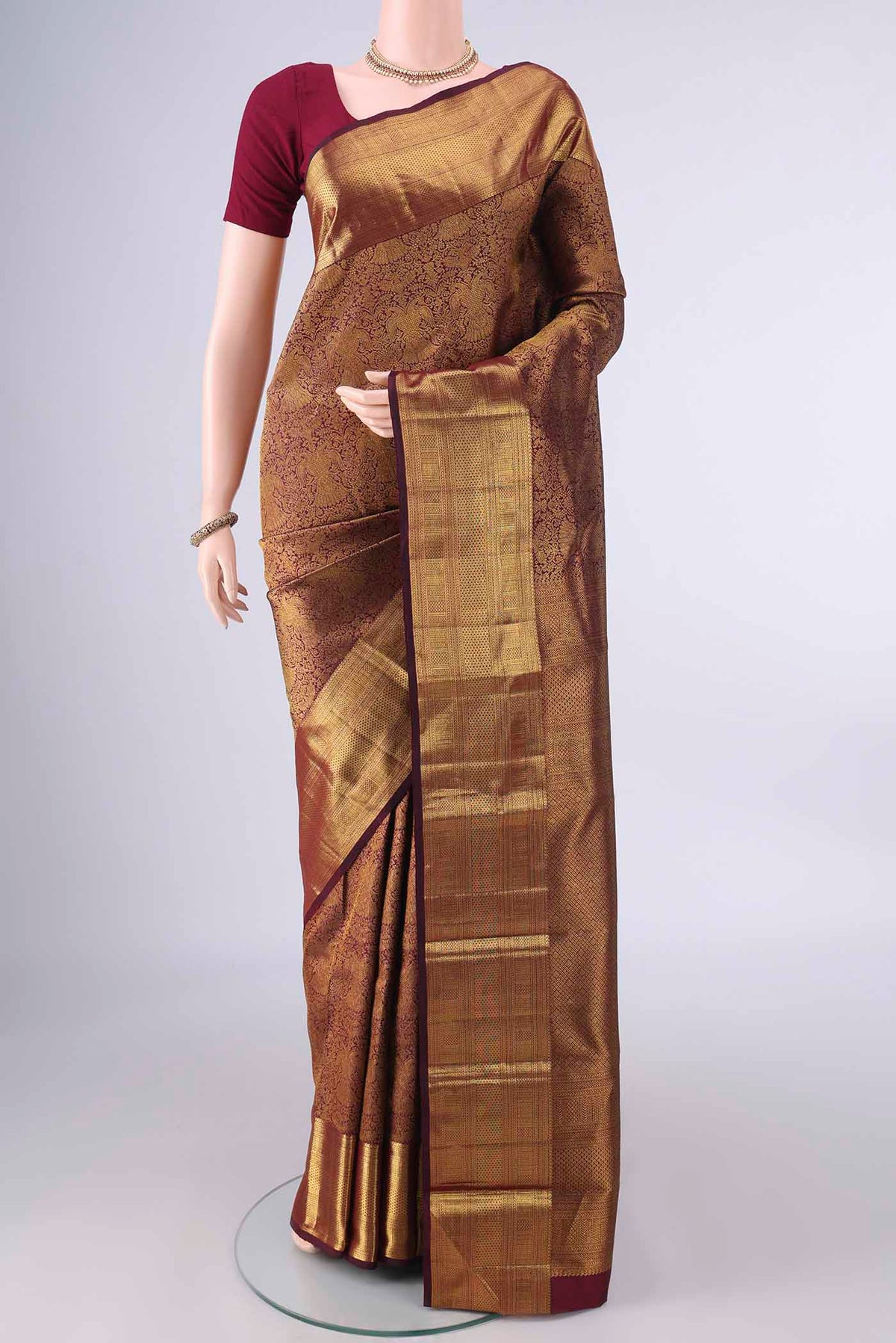 Pure Silk Maroon Kanchipuram Saree with Zari Brocade on the body and Zari Border.  displayed on a mannequin
