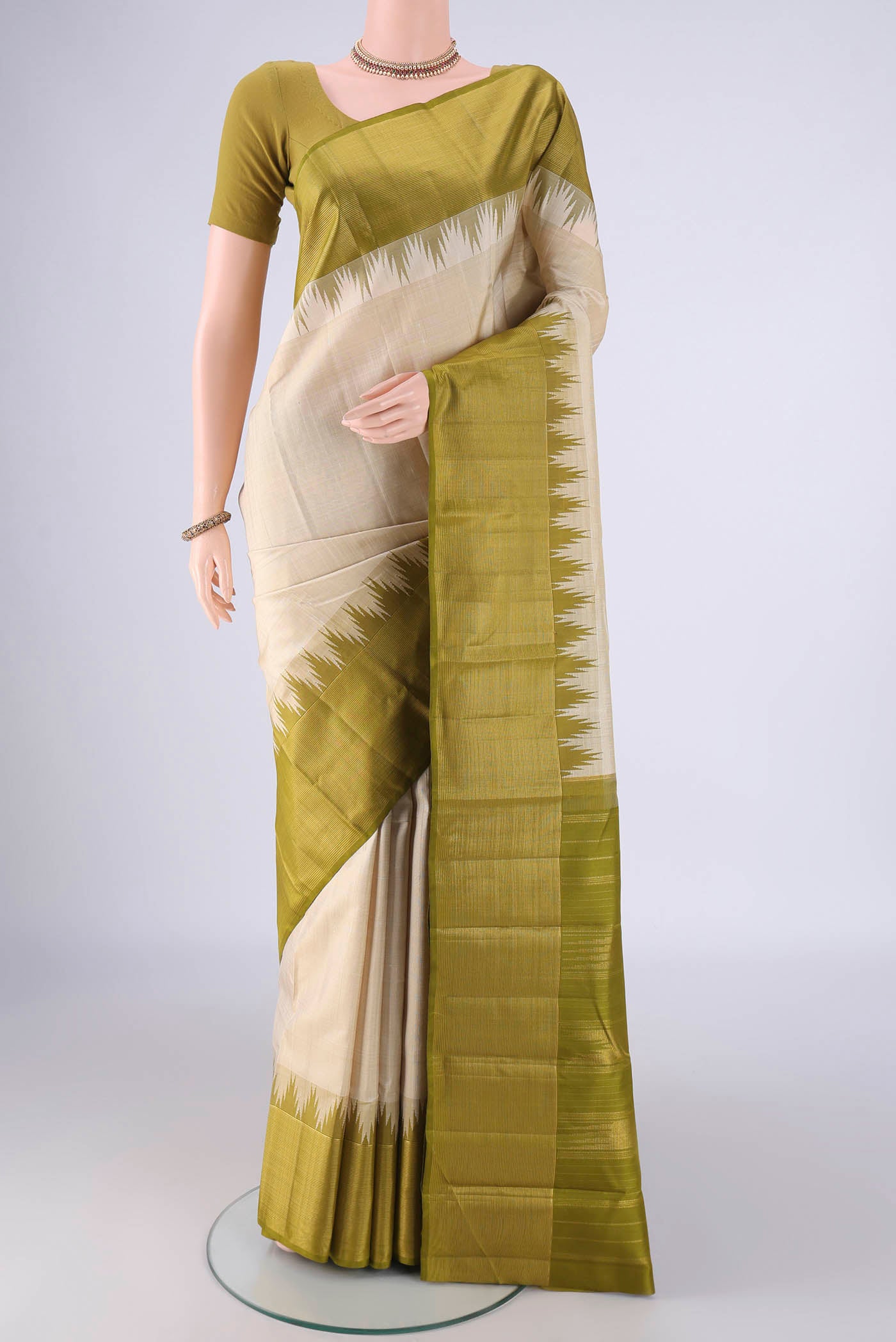 Off White Kanjivaram Silk Saree with Plain Body and Temple Border.  displayed on a mannequin