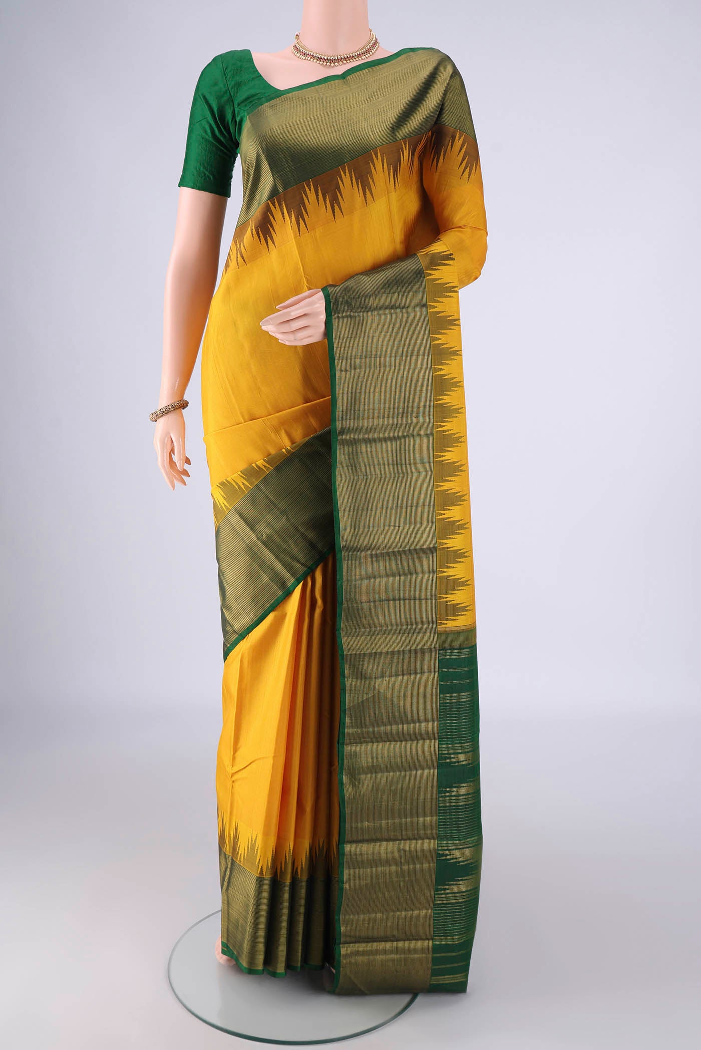 Yellow Kanjivaram Silk Saree with Plain Body and Temple Border.  displayed on a mannequin