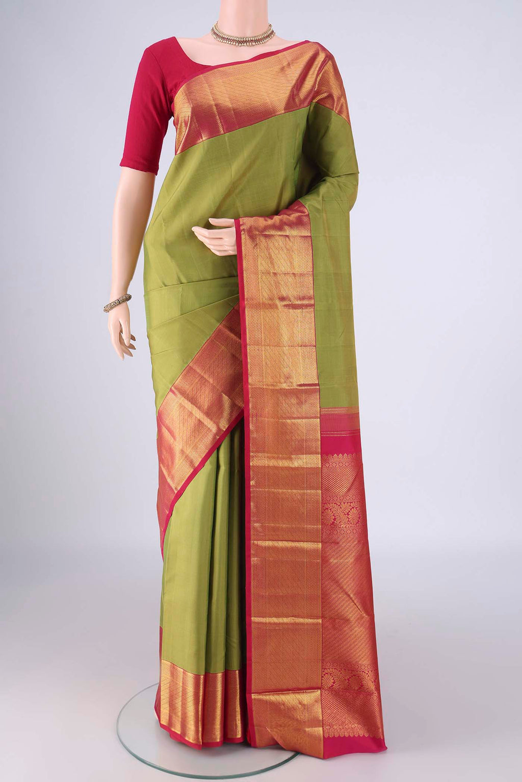 Light Green Kanjivaram Silk Saree with Plain Body and Zari Border.  displayed on a mannequin