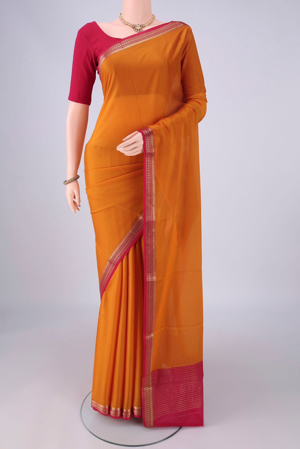 Mustard Mysore Crepe Saree with Plain Body and Zari Border.  displayed on a mannequin