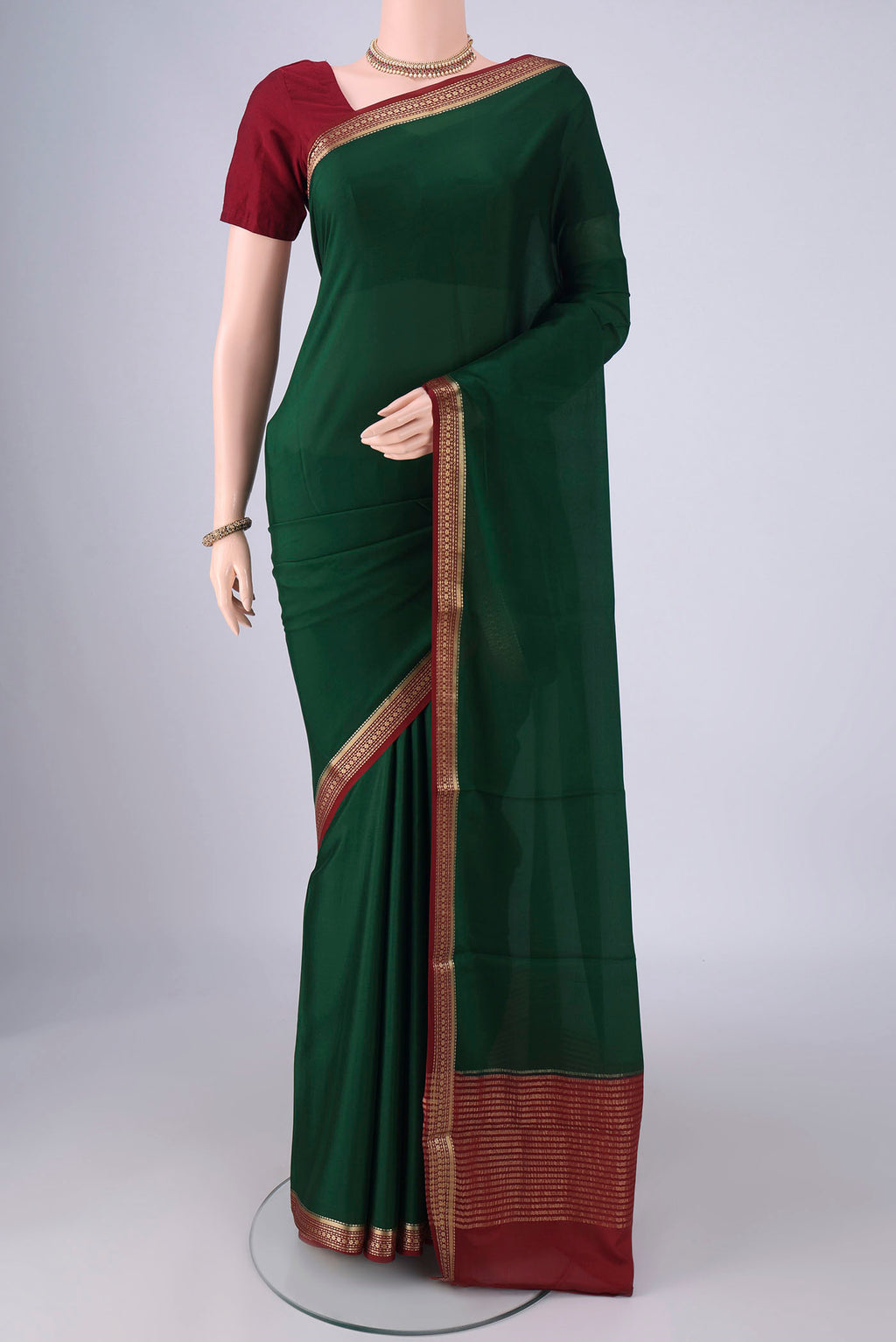 Bottle Green Mysore Crepe Saree with Plain Body and Zari Border.  displayed on a mannequin