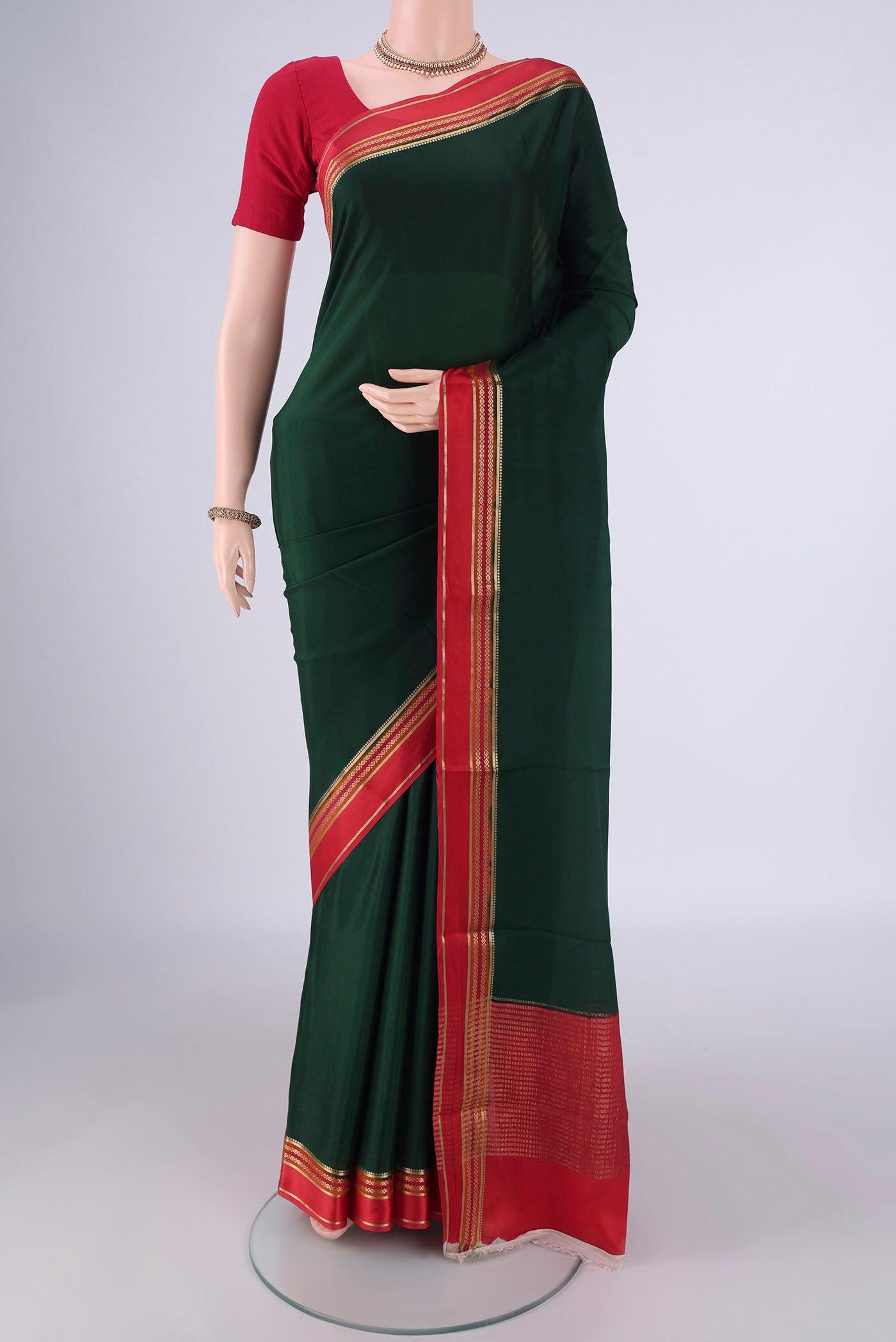 Bottle Green Mysore Crepe Saree with Plain Body and Zari Border.  displayed on a mannequin