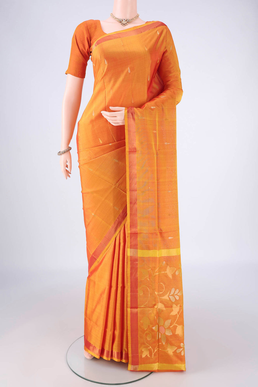 Mustard Uppada Silk Saree with Zari Butta on the body and Zari Border.  displayed on a mannequin