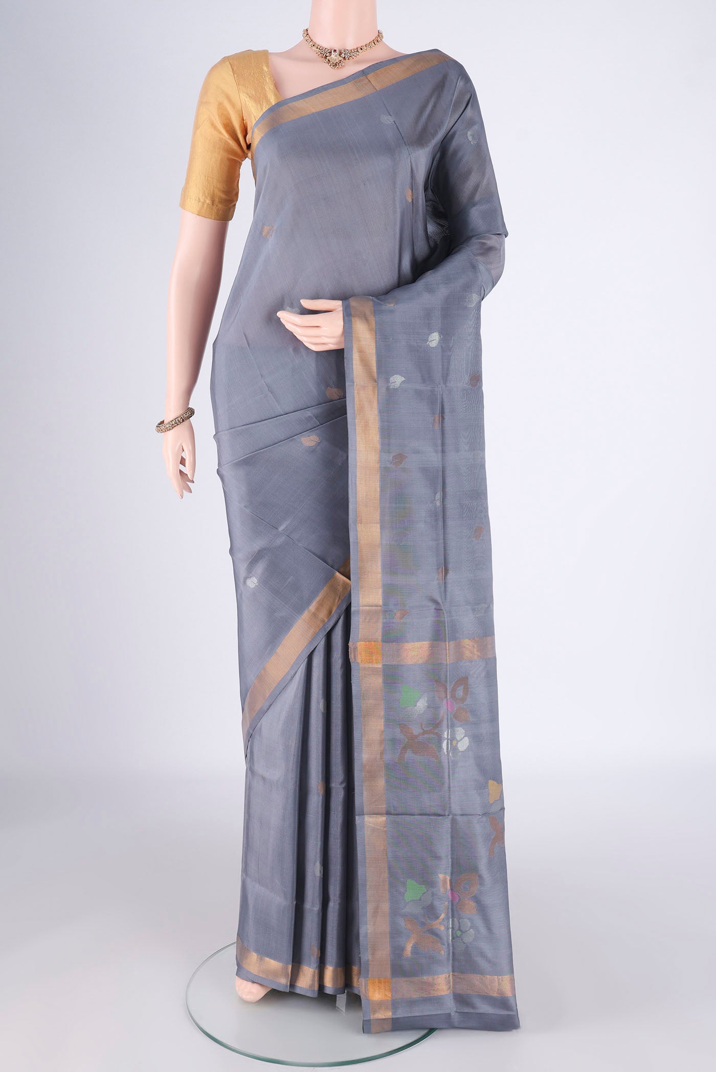 Grey Uppada Silk Saree with Zari Butta on the body and Zari Border.  displayed on a mannequin