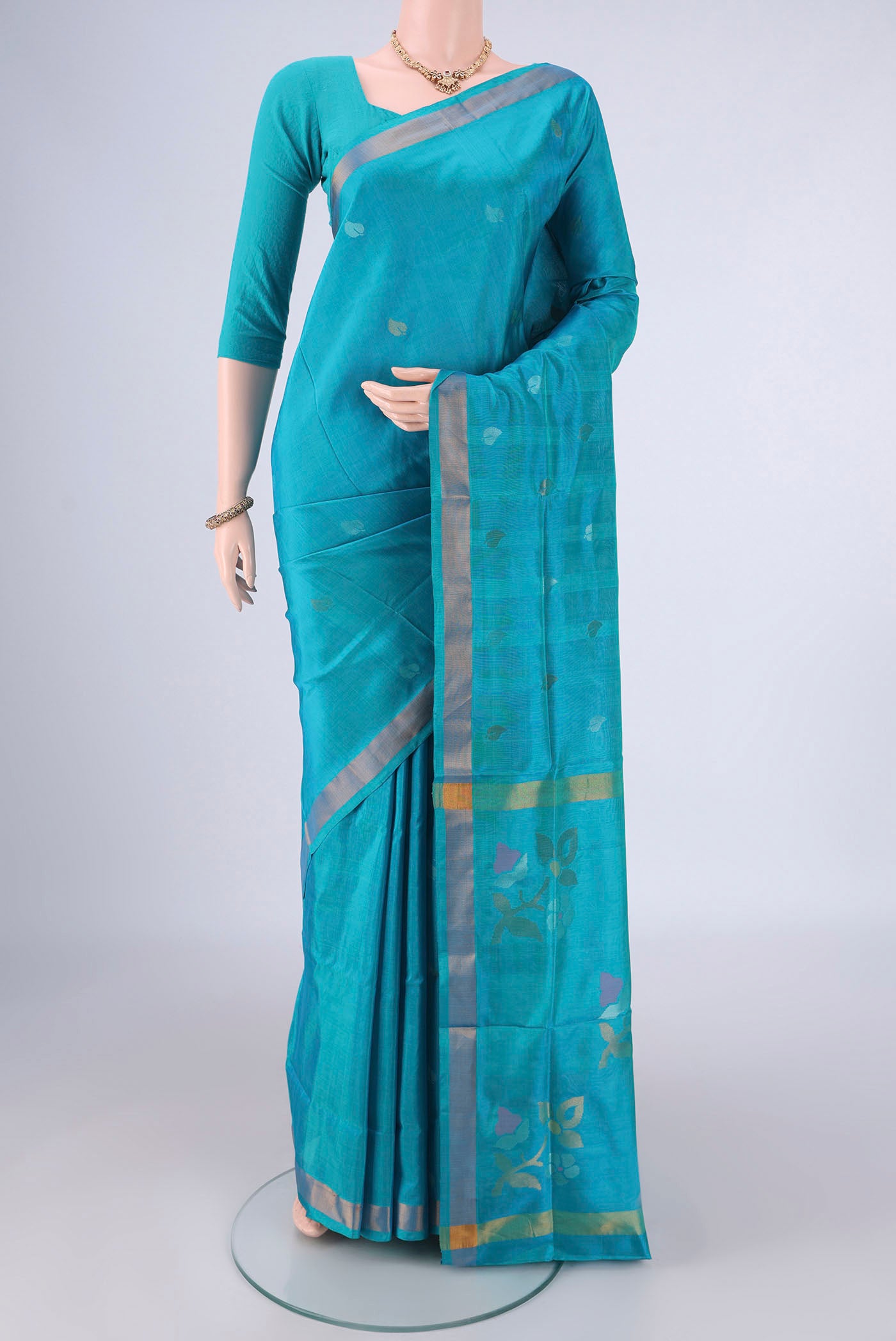 Turquoise Uppada Silk Saree with Zari Butta on the body and Zari Border.  displayed on a mannequin