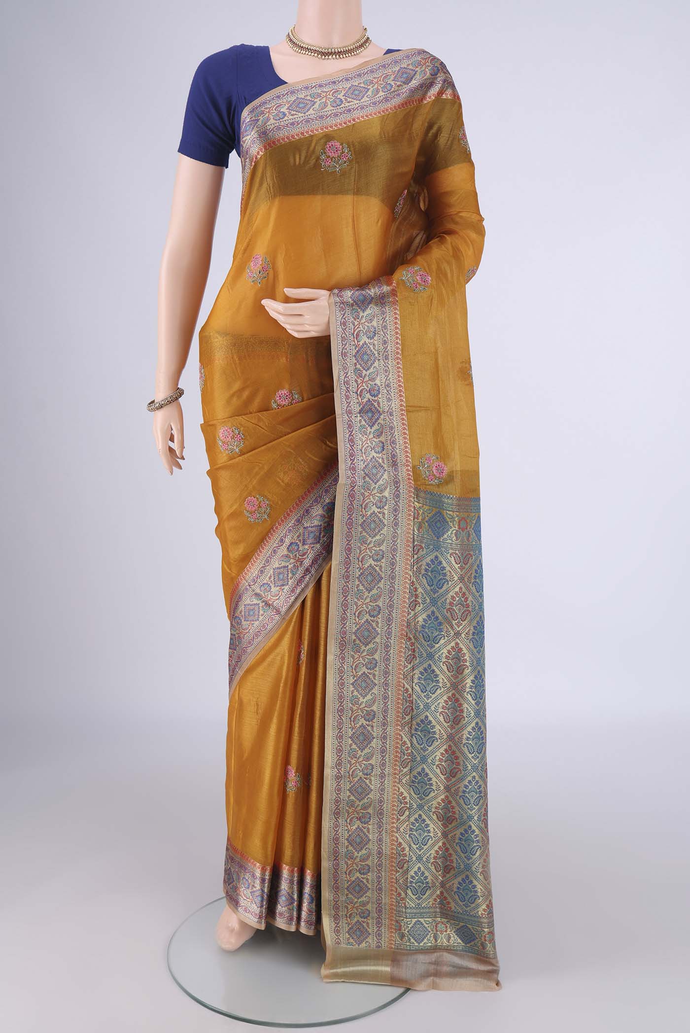 Mustard Banarasi Tussar Silk Saree with Embroidery on the body and Zari Border.  displayed on a mannequin