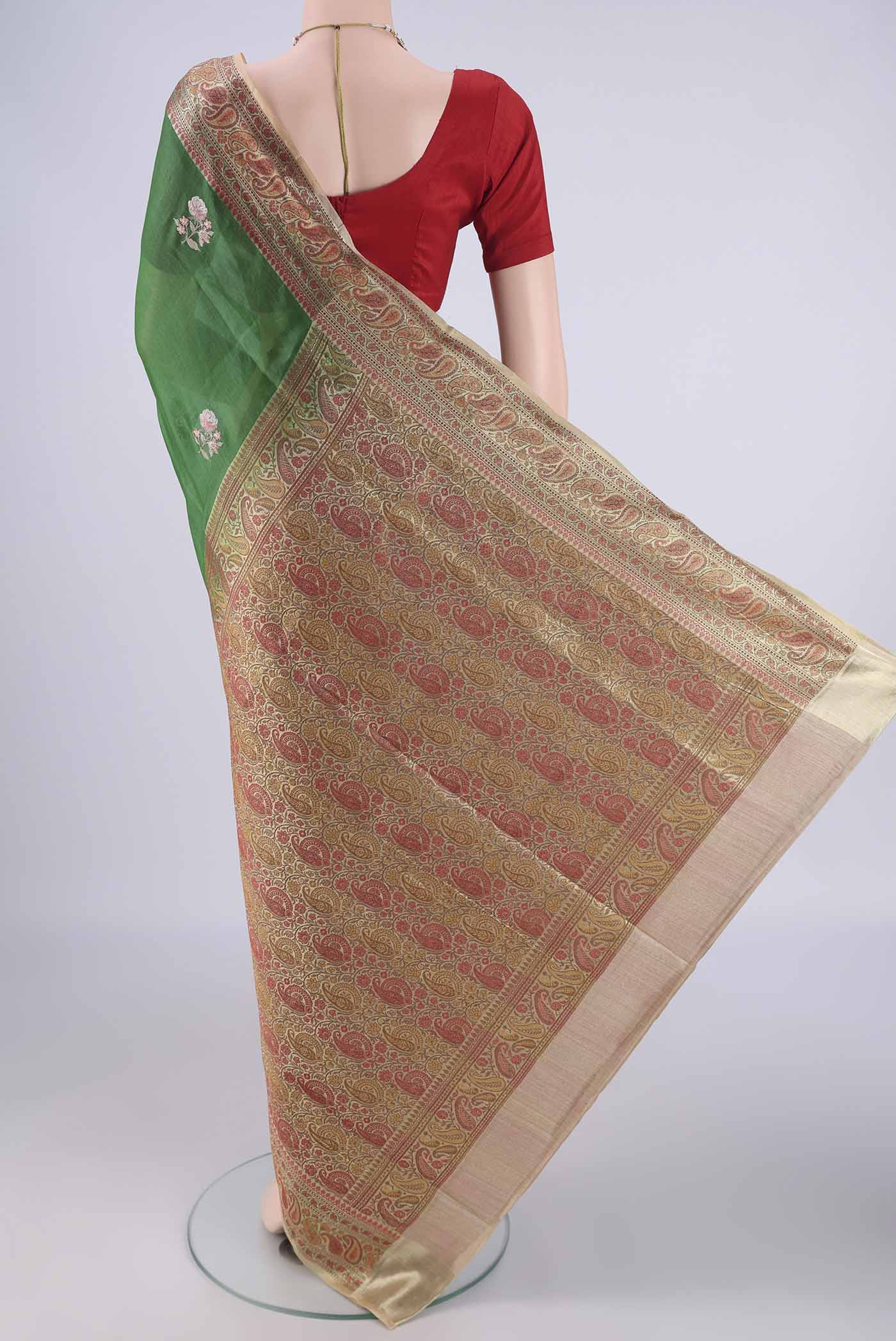 Flat view of Green Banarasi Tussar Silk Saree with Embroidery on the body and Zari And Thread Border. 