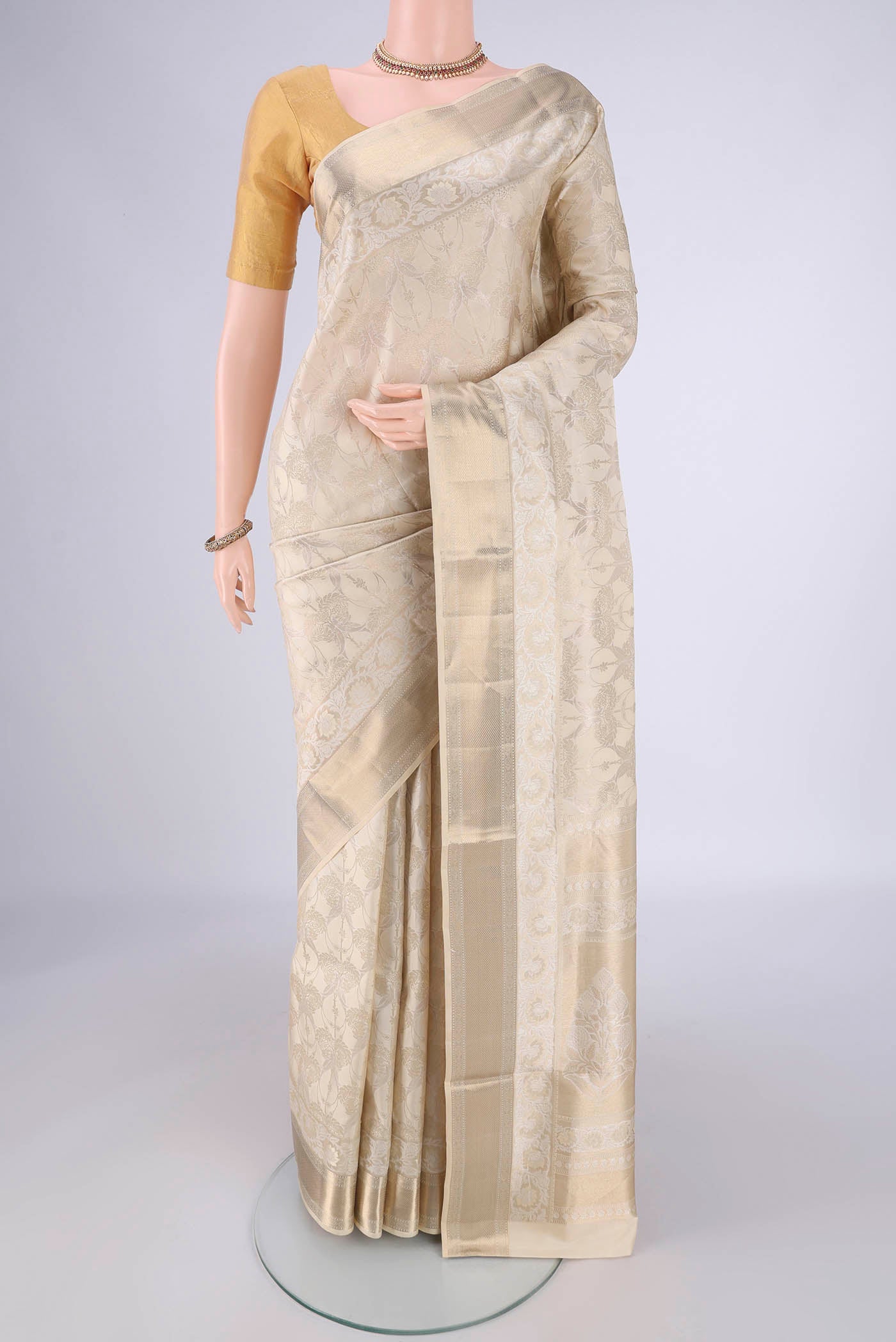 Off White Soft Silk Saree with Zari Brocade on the body and Zari Border.  displayed on a mannequin