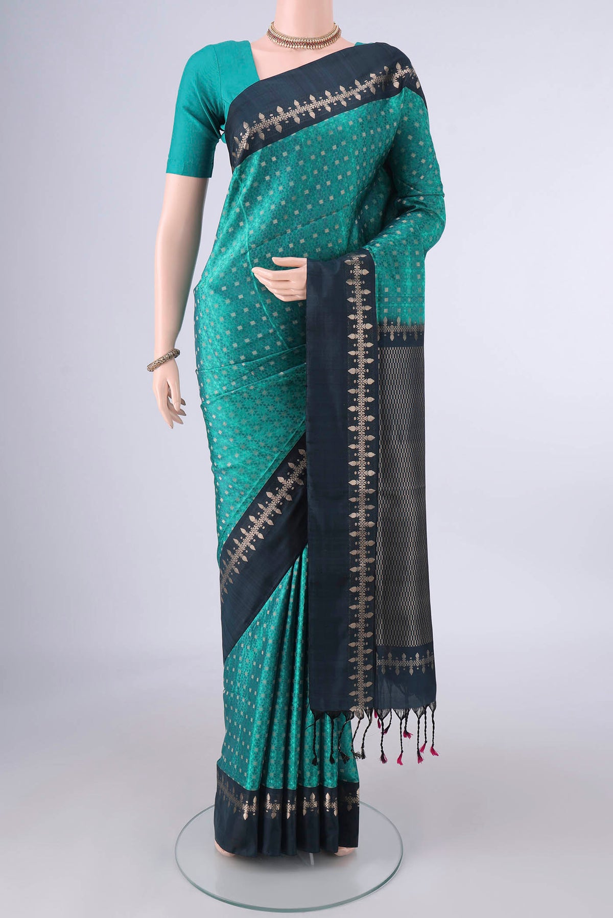 Pure Silk Sea Green Soft Saree with Jacquard With Zari Butta on the body and Zari And Thread Border.  displayed on a mannequin