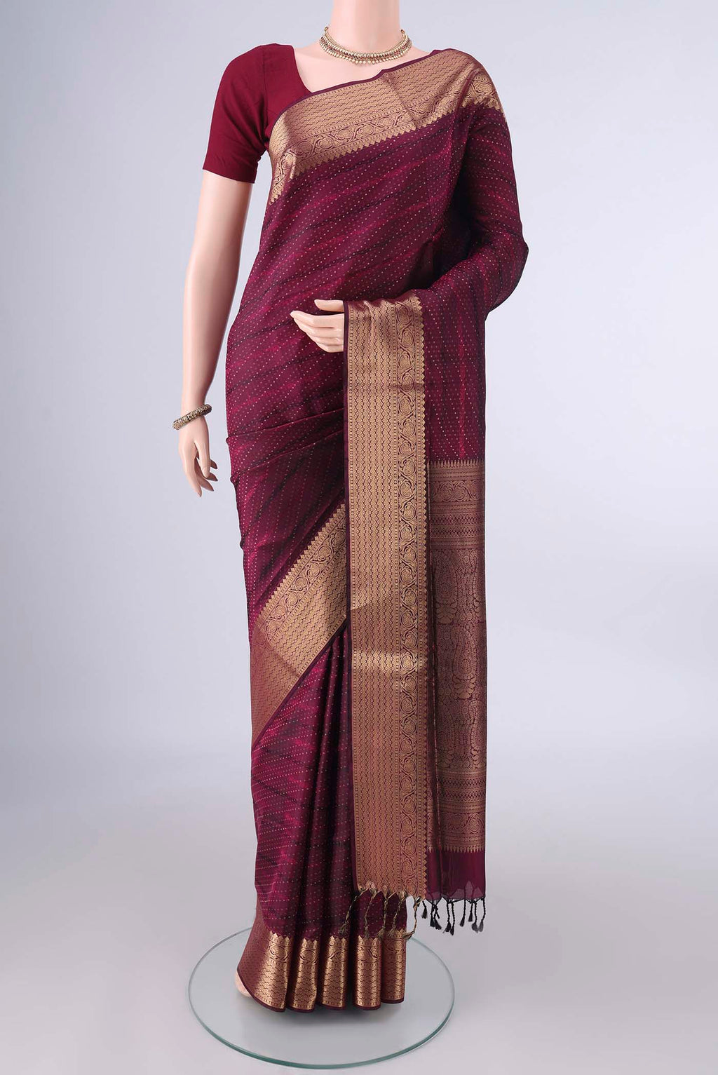 Pure Silk Maroon Soft Saree with Jacquard With Zari Butta on the body and Zari And Thread Border.  displayed on a mannequin