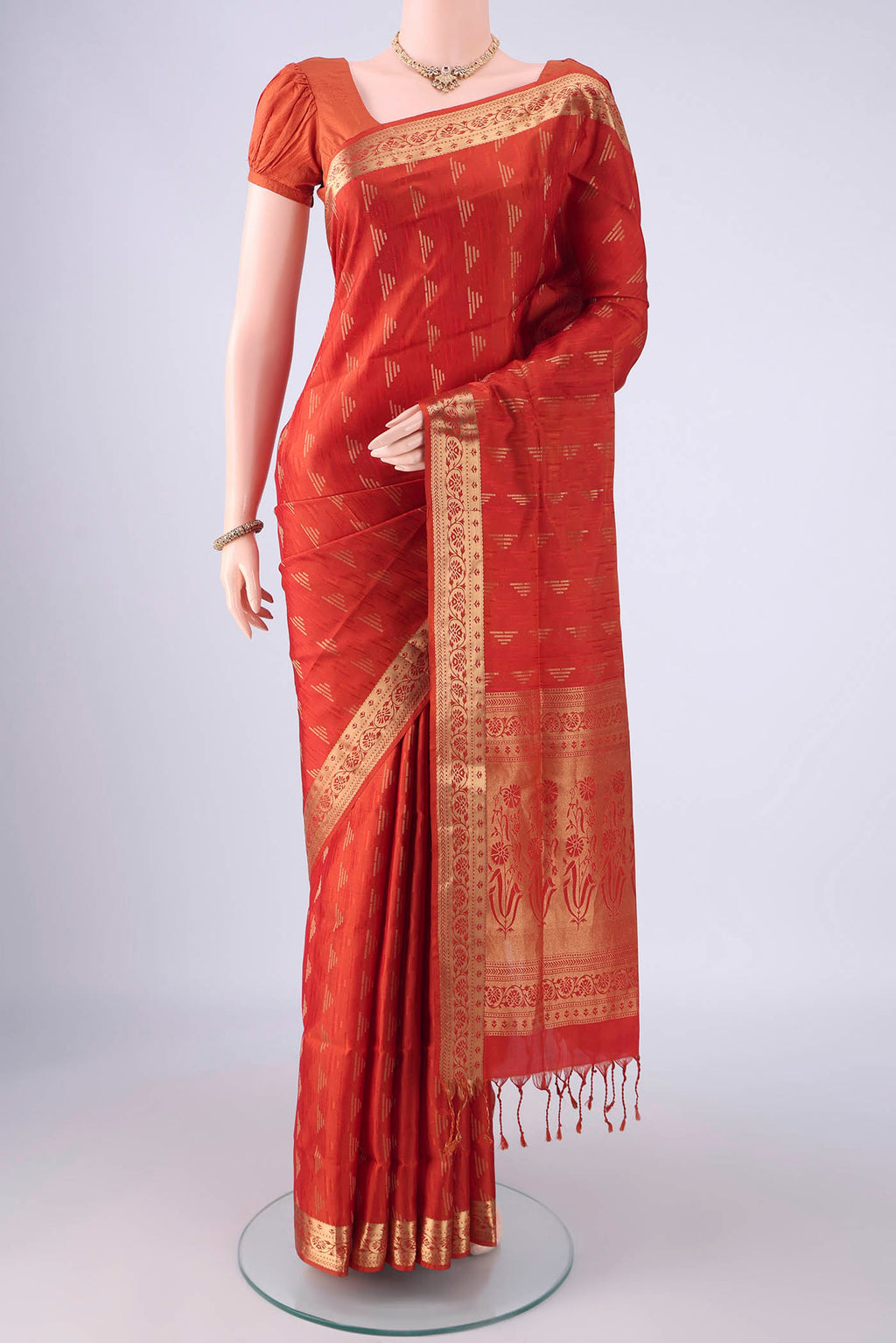 Brick Orange Soft Silk Saree with Jacquard With Zari Butta on the body and Zari Border.  displayed on a mannequin