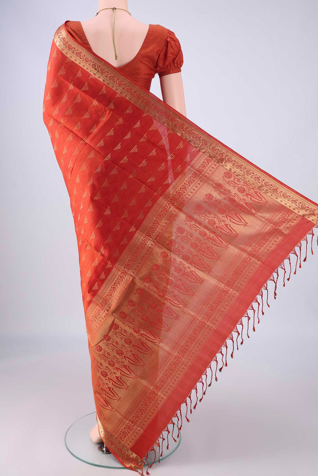 Flat view of Brick Orange Soft Silk Saree with Jacquard With Zari Butta on the body and Zari Border. 