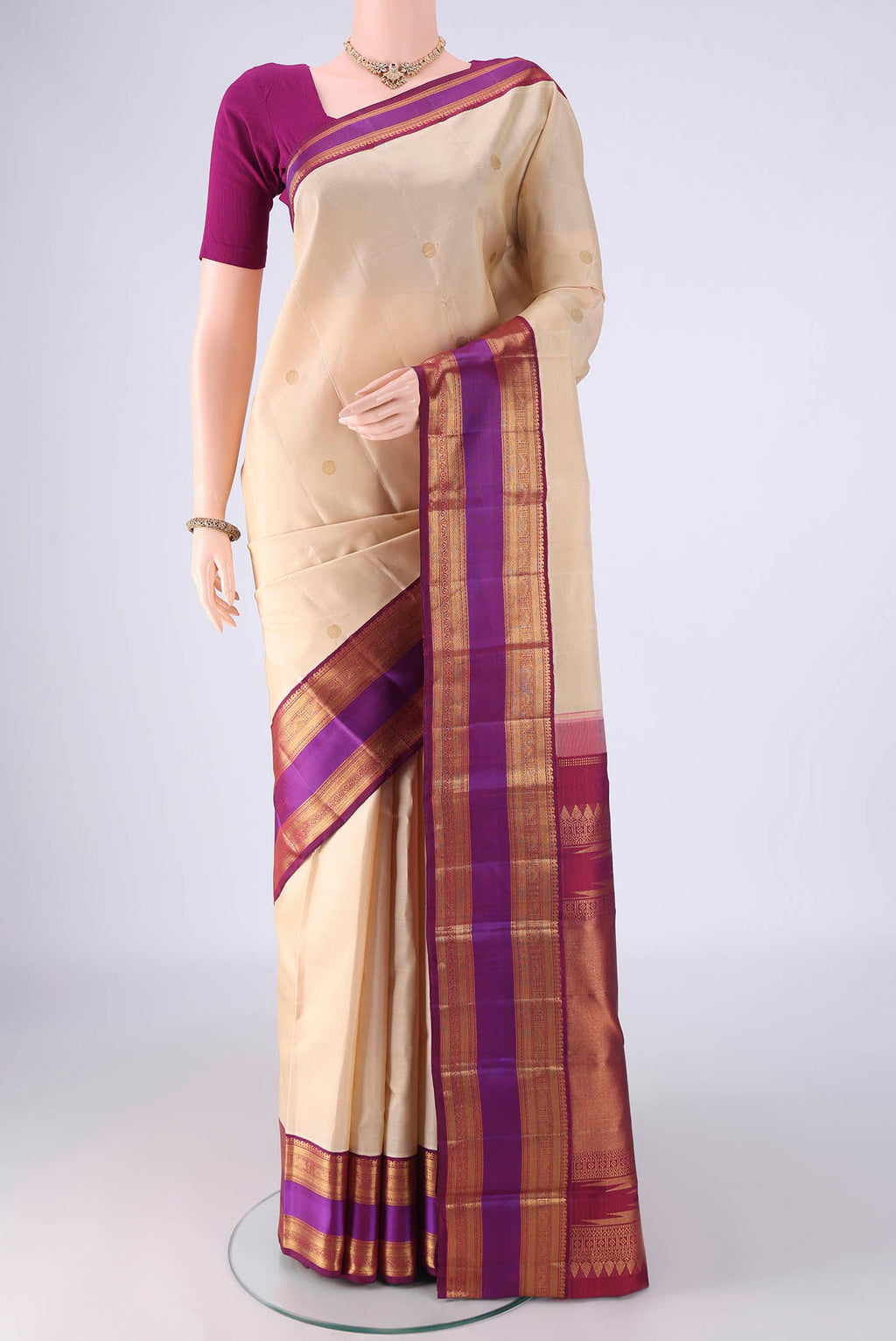 Cream Kanjivaram Silk Saree with Zari Butta on the body and Zari Border.  displayed on a mannequin