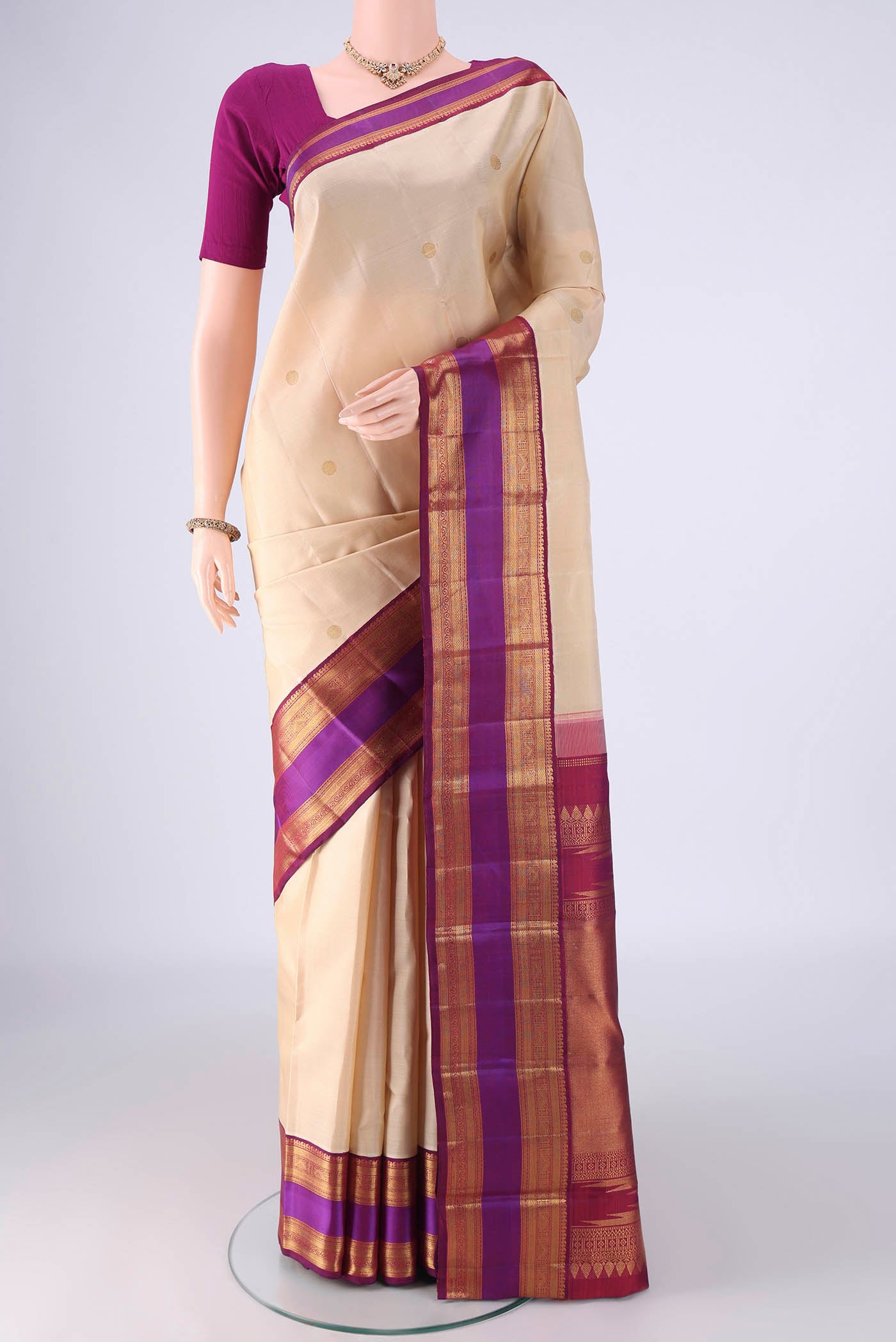 Cream Kanjivaram Silk Saree with Zari Butta on the body and Zari Border.  displayed on a mannequin
