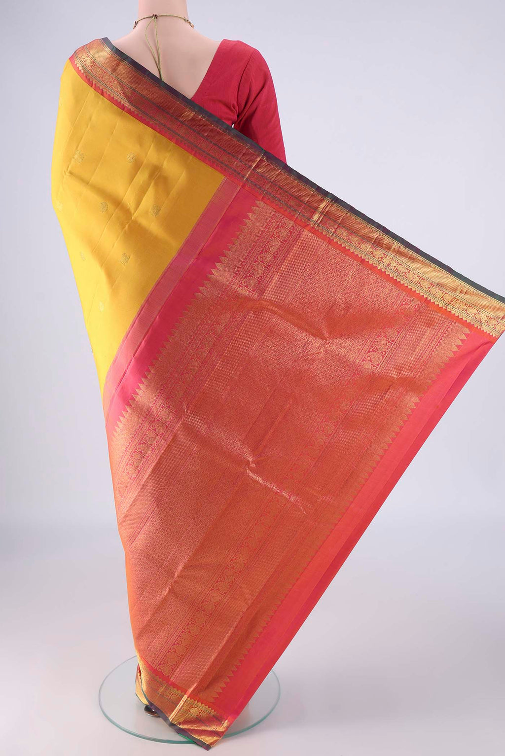 Flat view of Yellow Kanjivaram Silk Saree with Zari Butta on the body and Zari Border. 