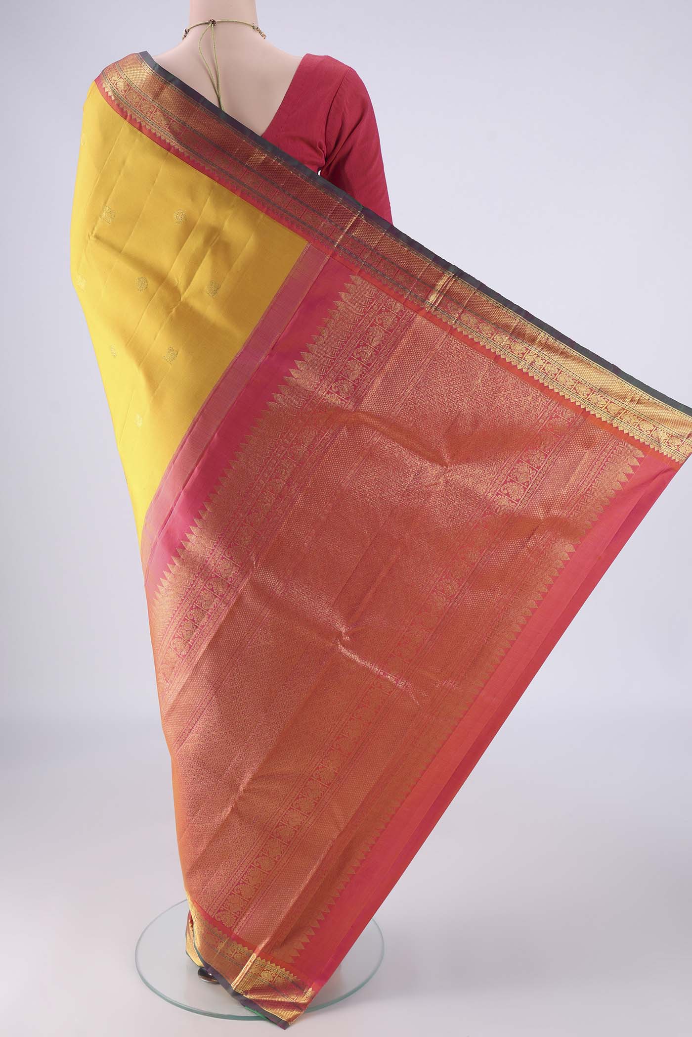 Flat view of Yellow Kanjivaram Silk Saree with Zari Butta on the body and Zari Border. 