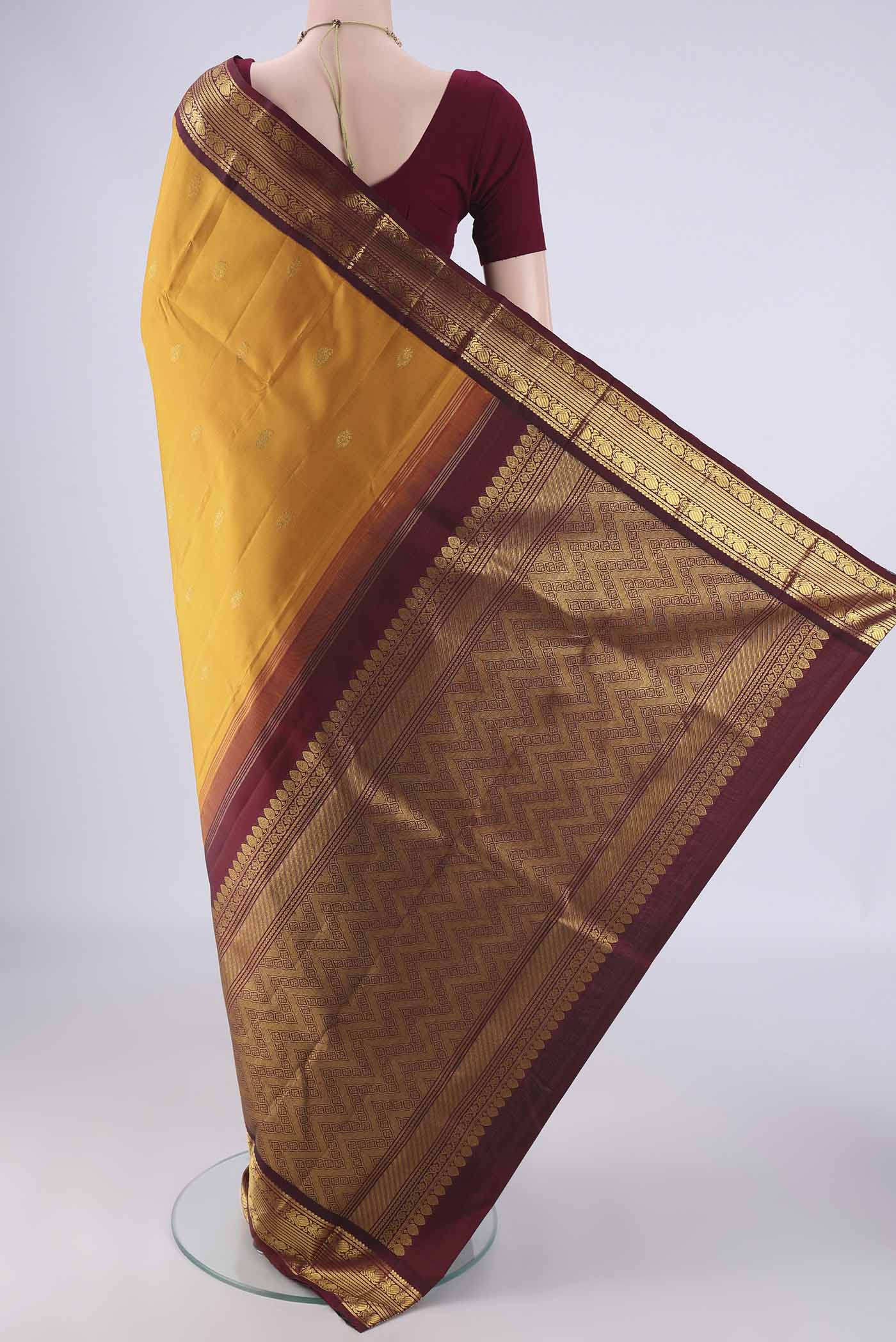 Flat view of Mustard Kanchipuram Silk Saree with Zari Butta on the body and Zari Border. 