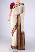 Off White Kanchipuram Silk Saree with Zari Butta on the body and Zari Border.  displayed on a mannequin